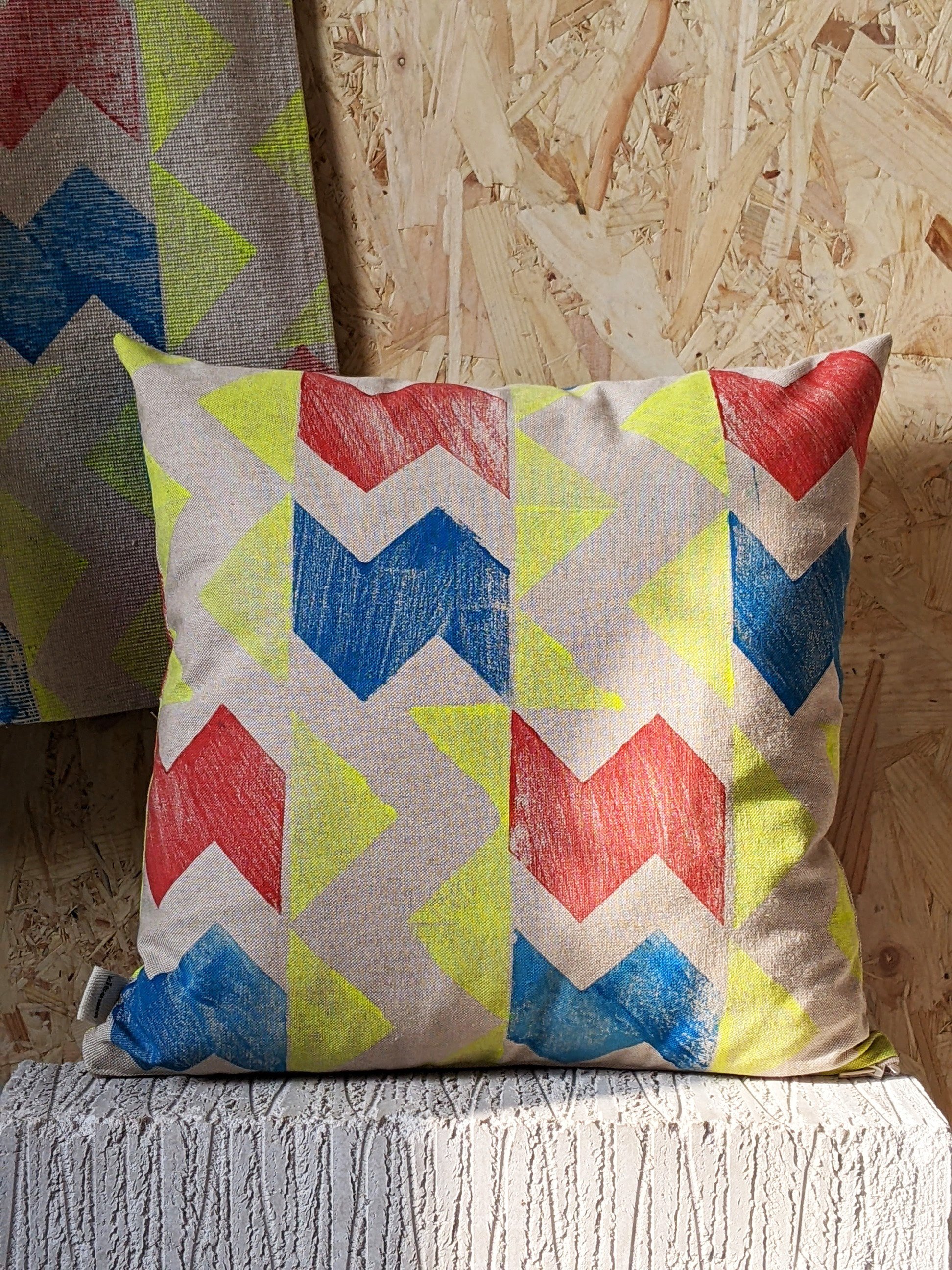 yellow printed cushion with red and blue zig zag print