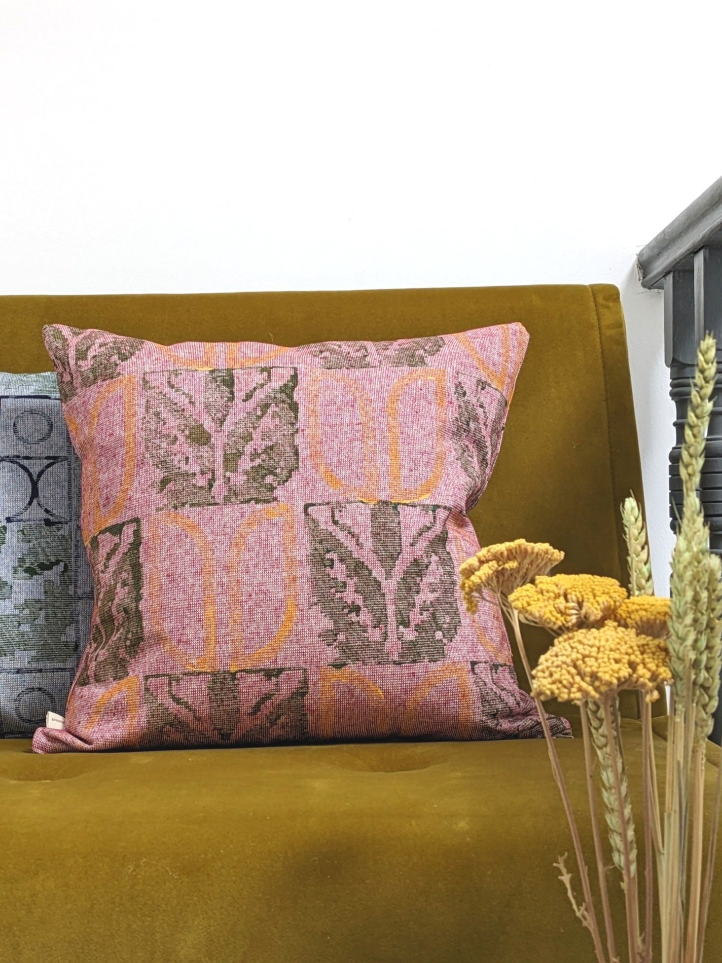 cosy interior scene with red cushions on dark mustard seat