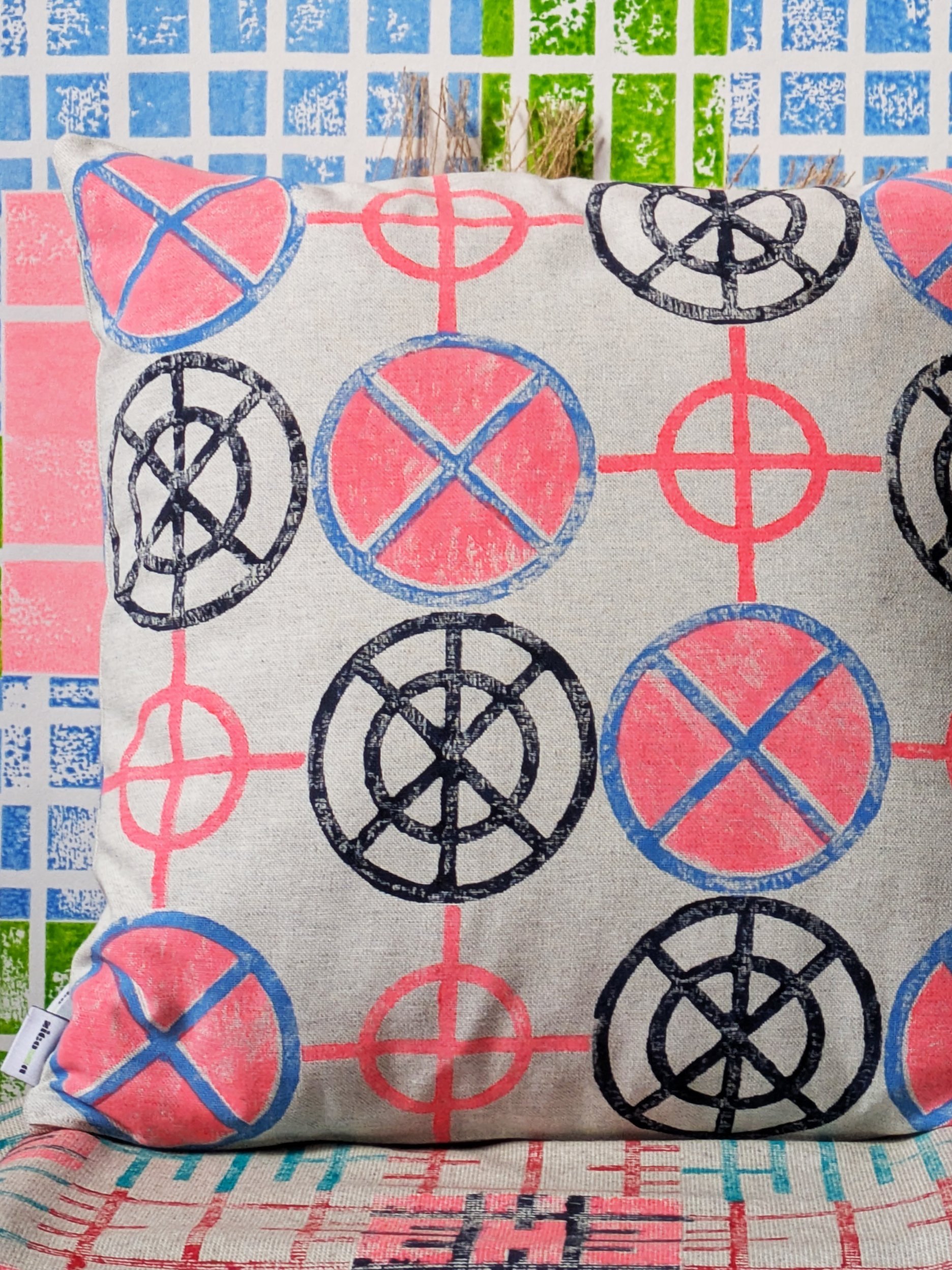 bright cushion with circular bold industrial pattern in neon colours in colourful interior scene