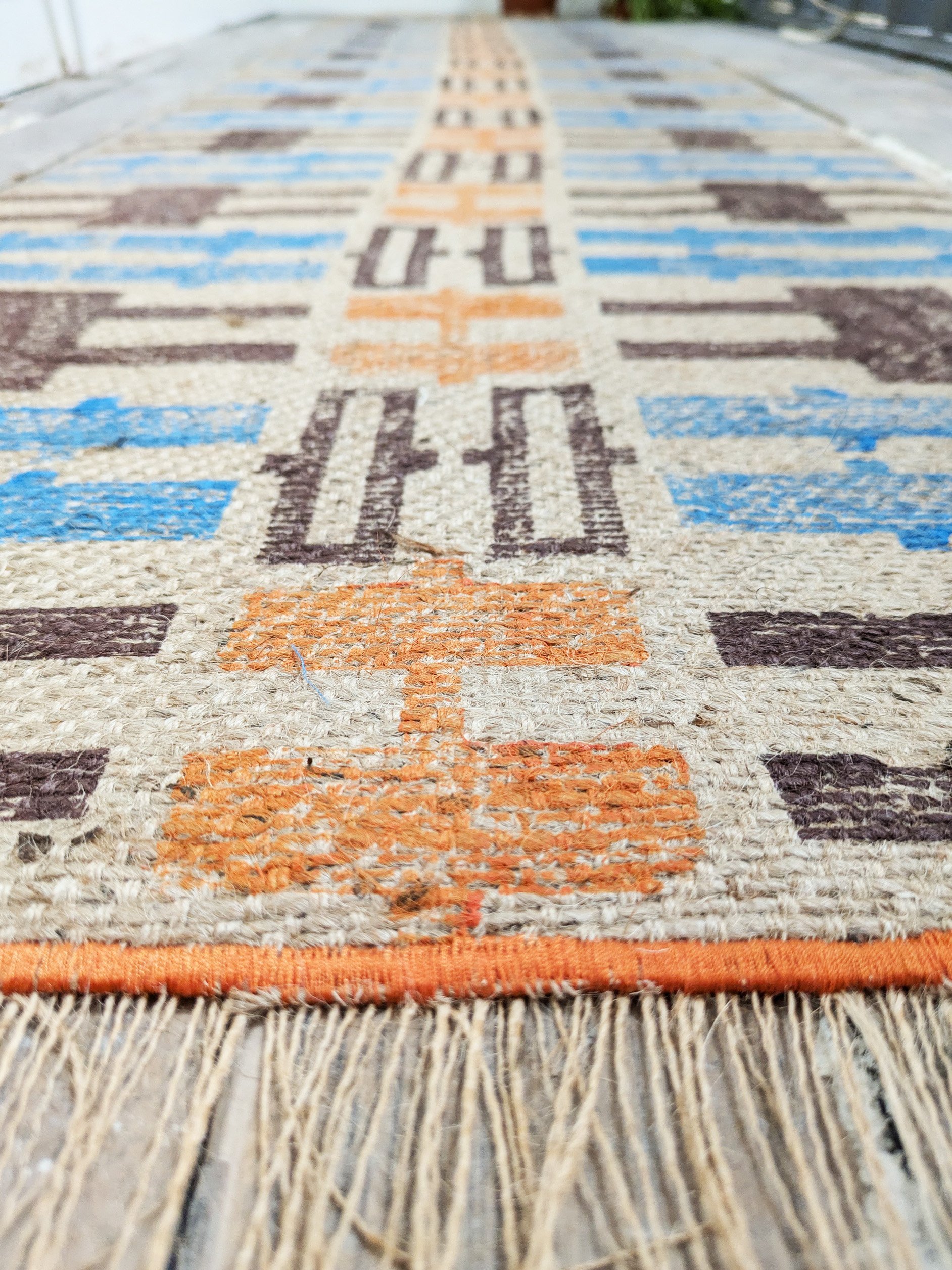 close-up detail of hand block printed jute runner in warm colours and geometric pattern