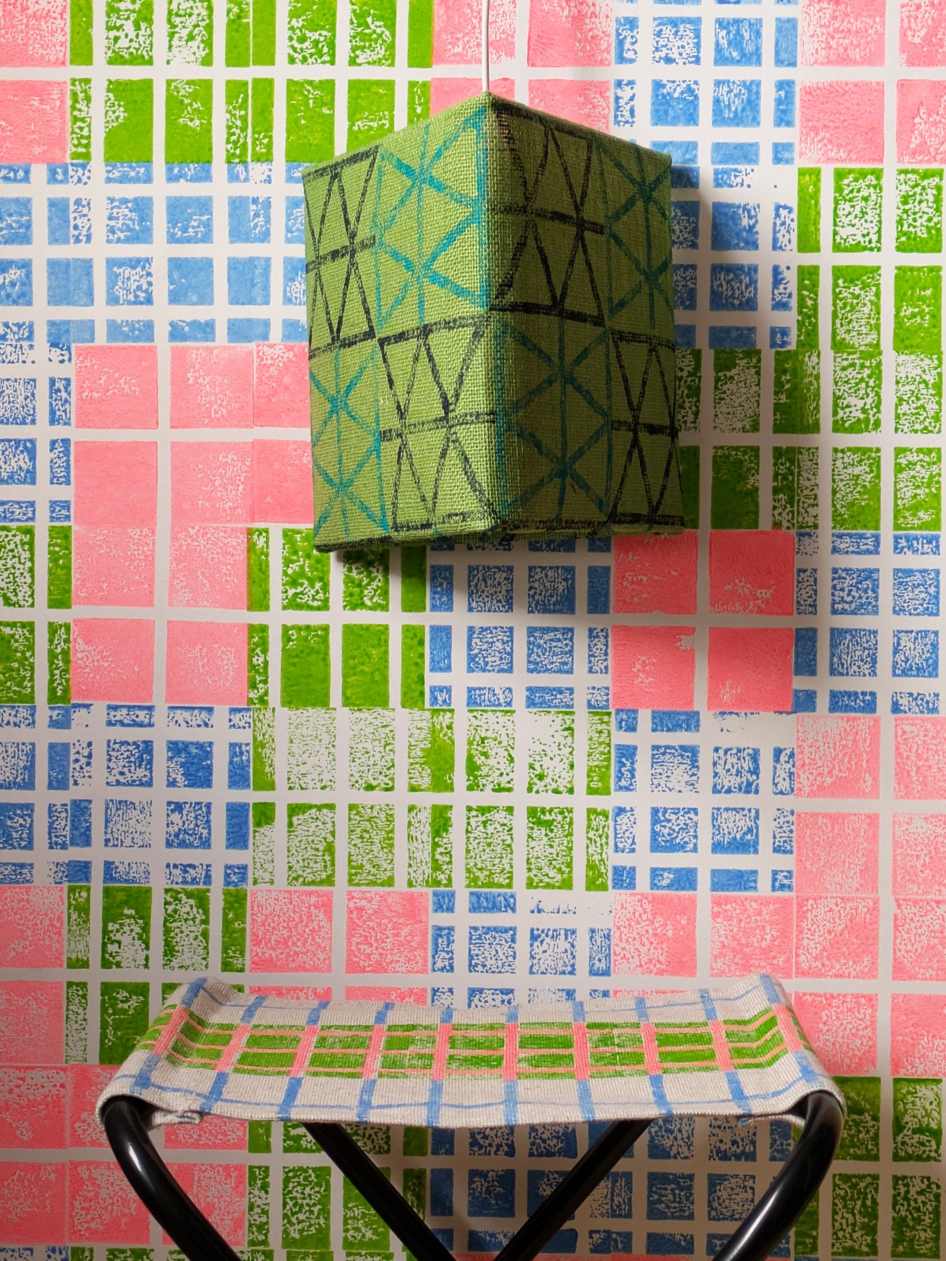 bright studio scene with grid pattern wallpaper in fun neon colours and green triangular lampshade