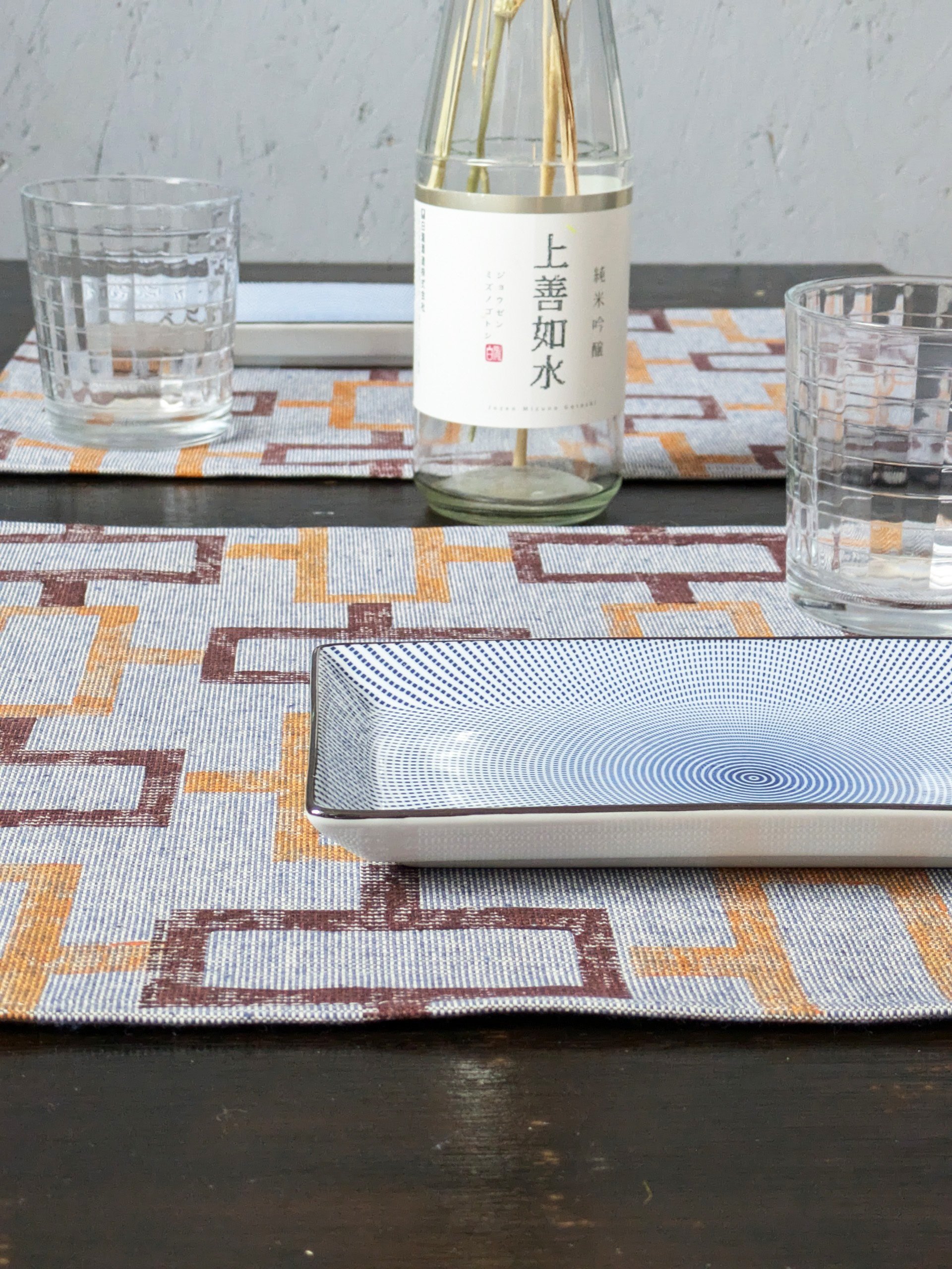 close-up detail of hand block printed pattern on denim-like placemat on japanese-inspired table set
