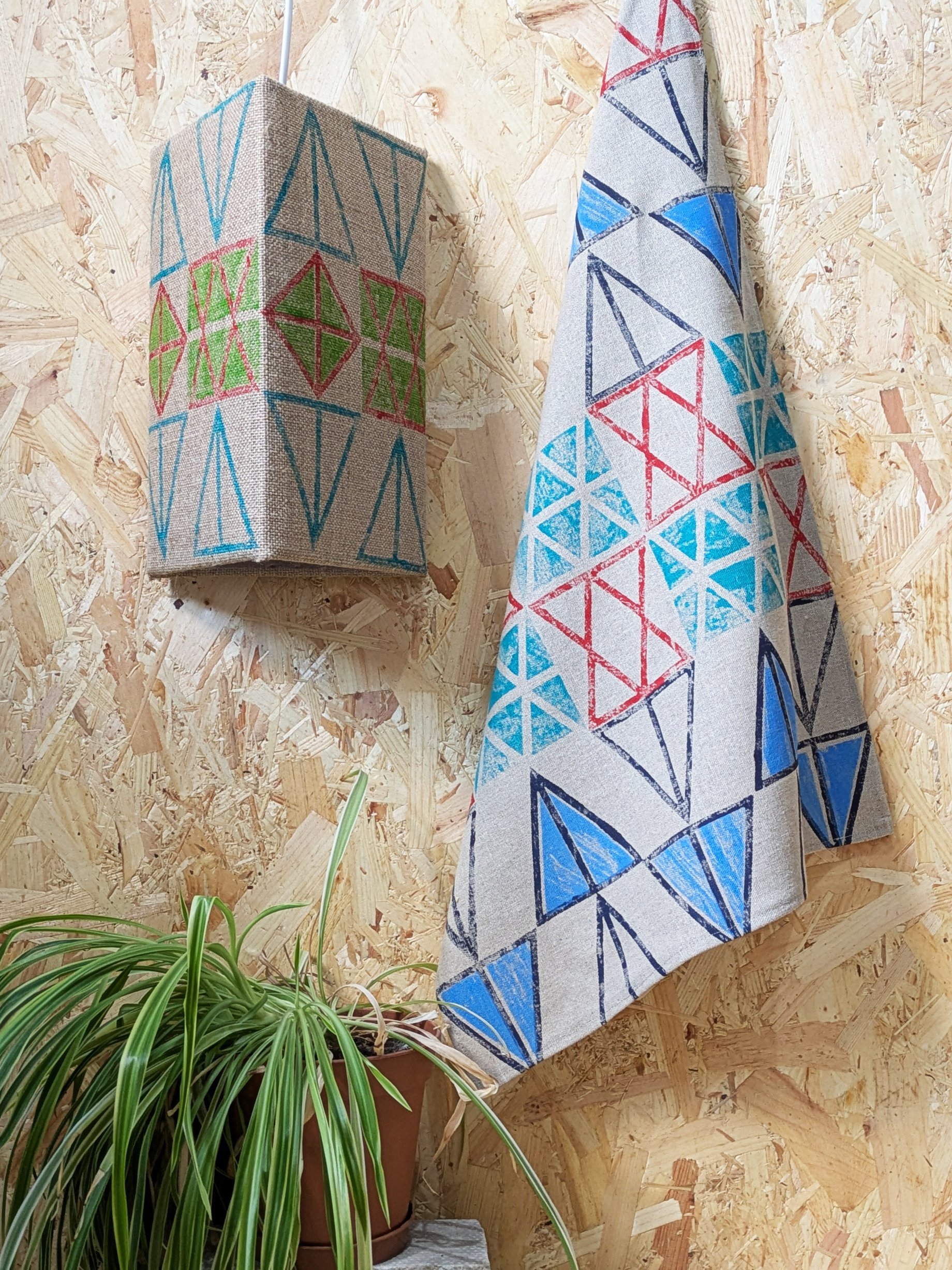 studio scene with triangular block printed teatowel next to triangle framed jute lampshade in bold print