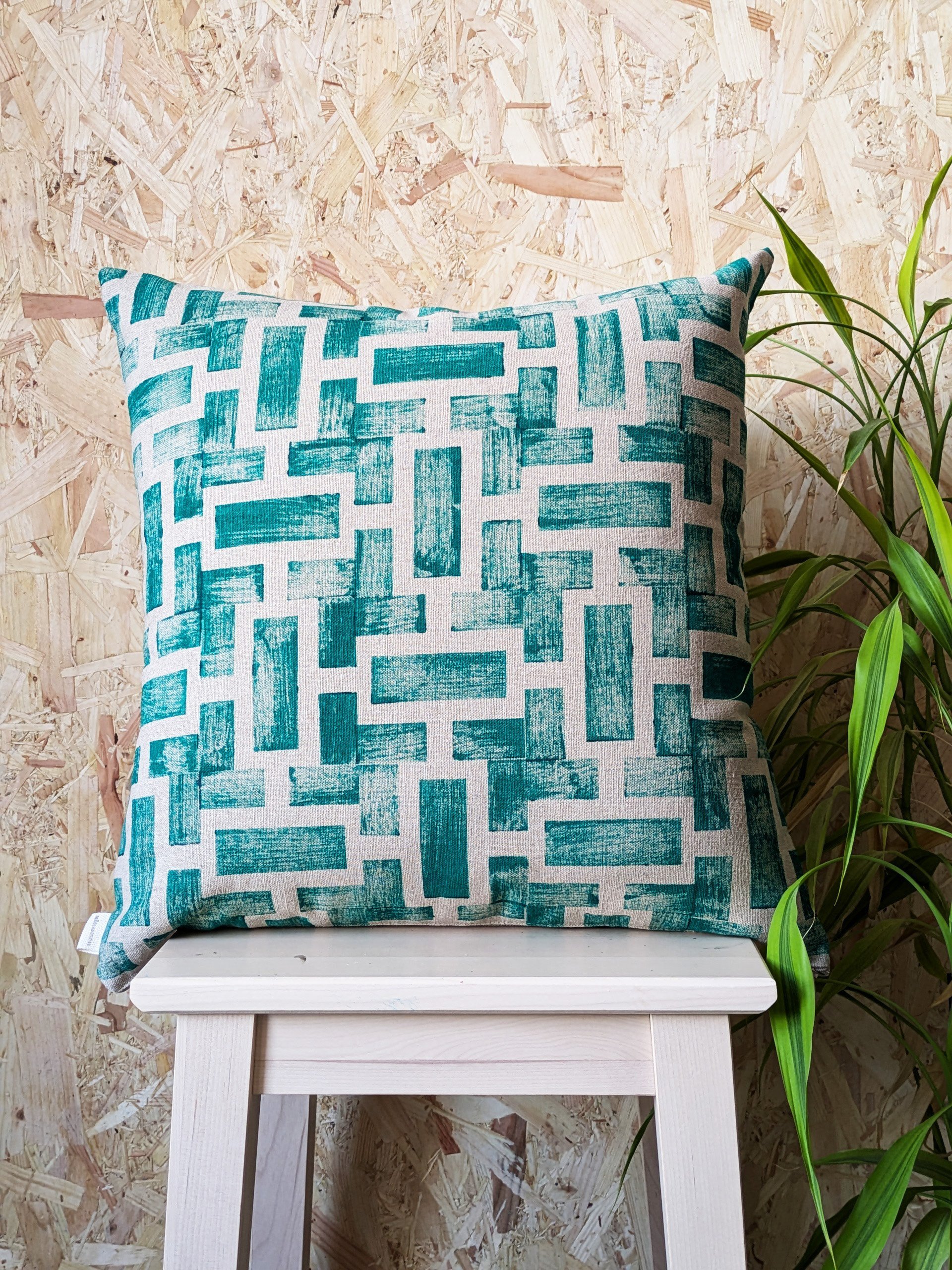 lush green print on abstract geometric linen cushion in modern interior design