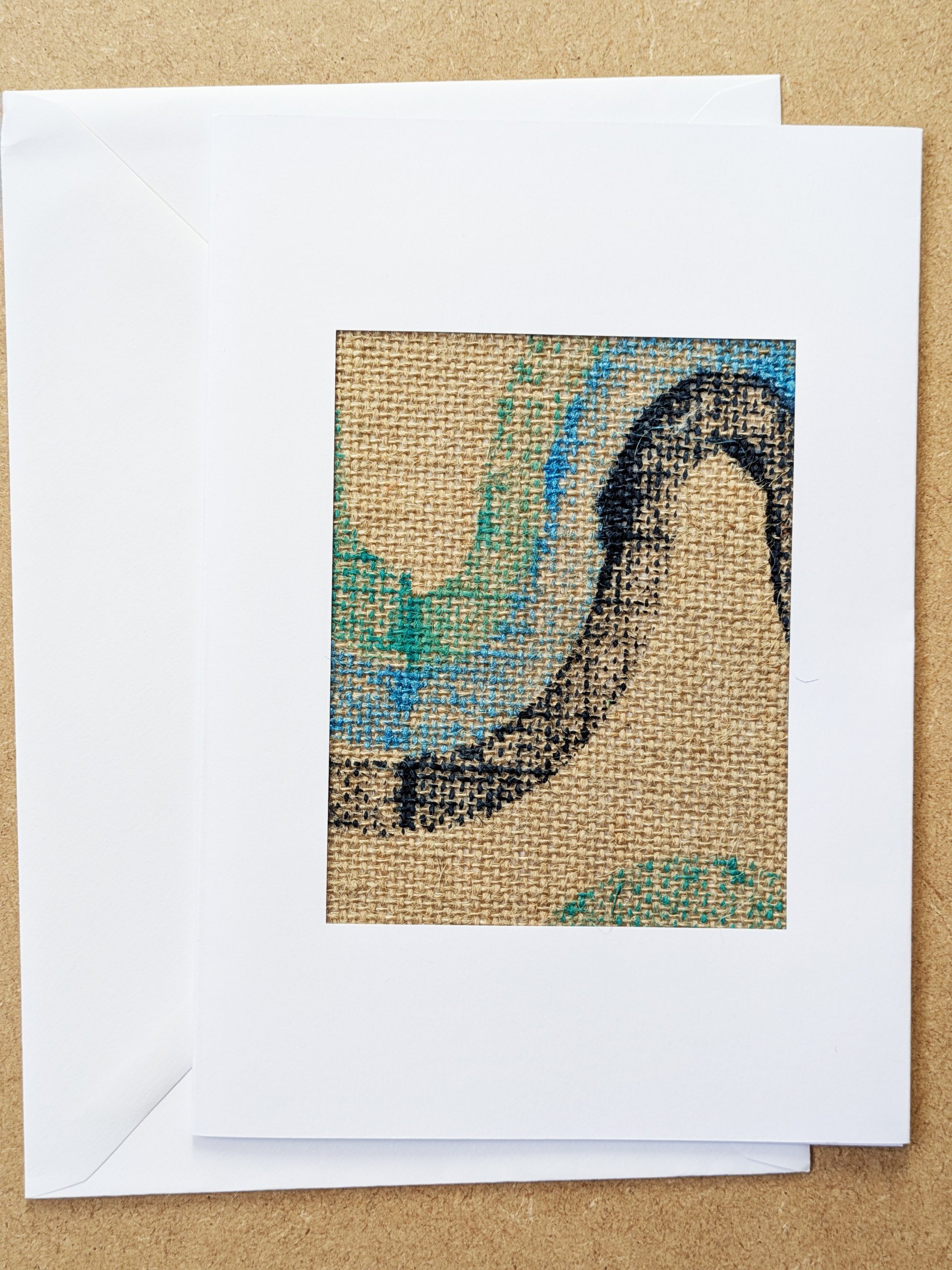 blue wave-shaped block printed pattern framed in white postcard frame and white envelope