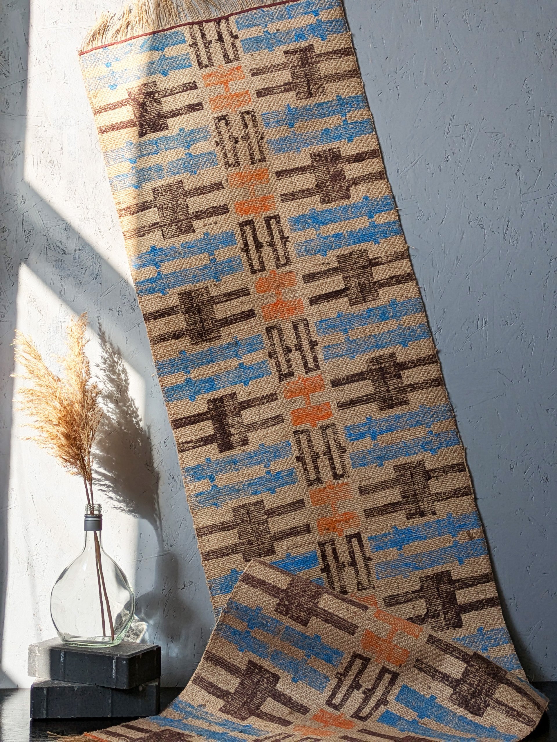 geometric block printed jute rug in sunlit studio with warm colours and aztec-inspired patterns