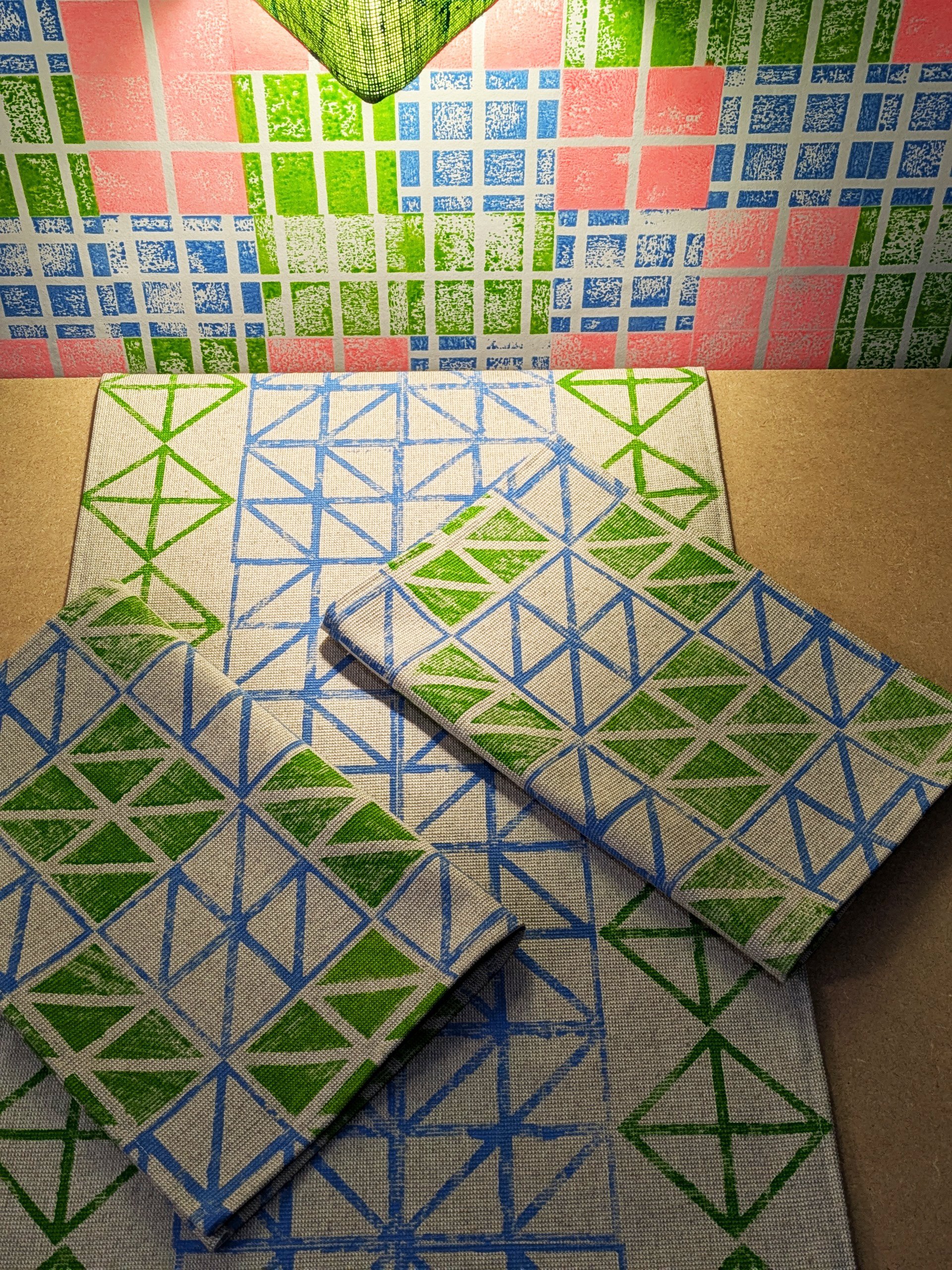 studio table scene with table runner, triangular light and place mats in modern contemporary colourways