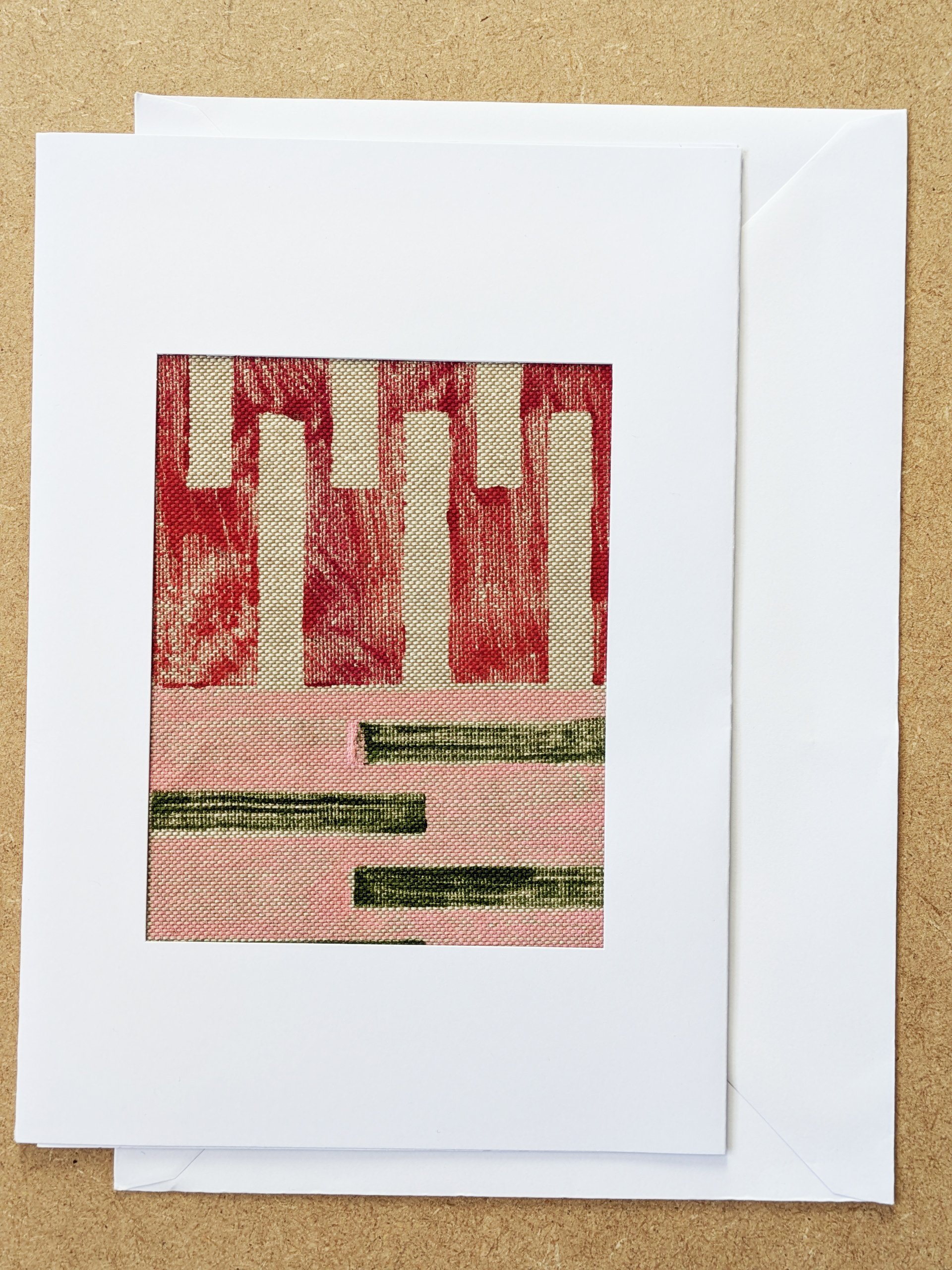 red and pink abstract, geometric architecture inspired textile print framed in white postcard frame and white envelope