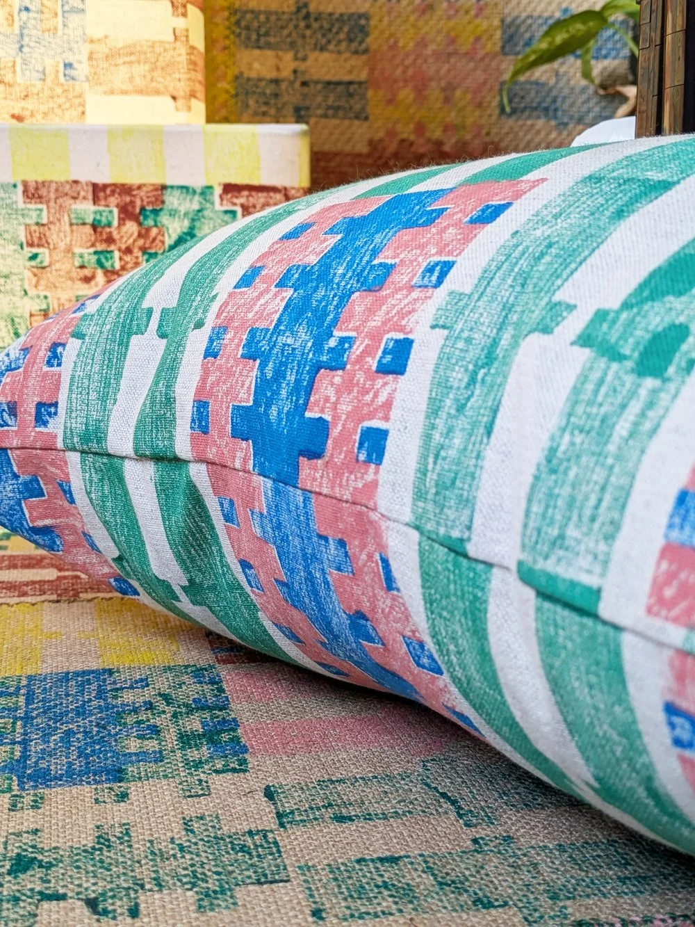 close-up detail of hand printed cushion with bold summer stripe print in architectural inspired bright green pattern