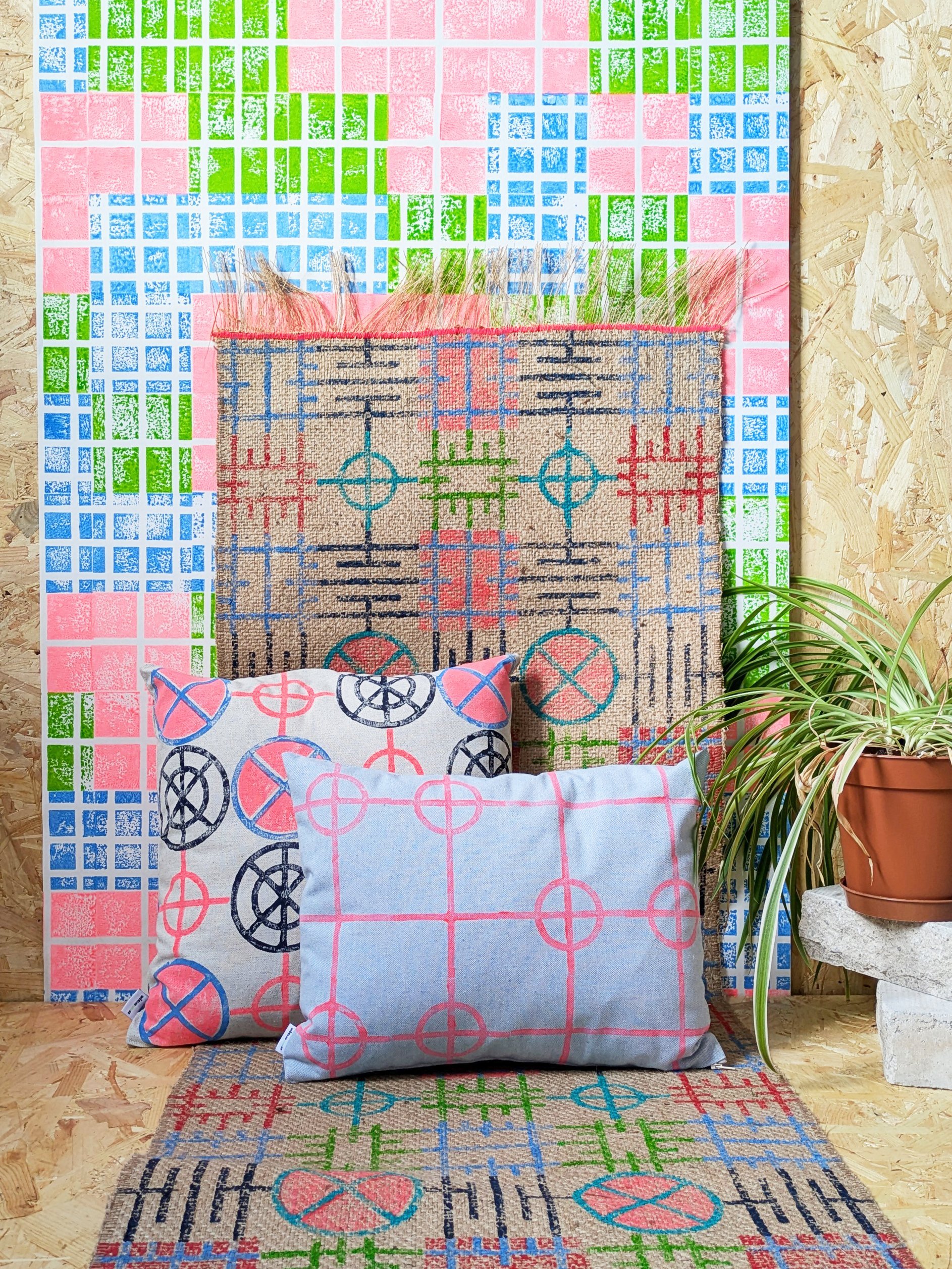 colourful interior scene with bright wallpaper in neon colours, a block printed jute runner and two cushions in circular geometric modern print