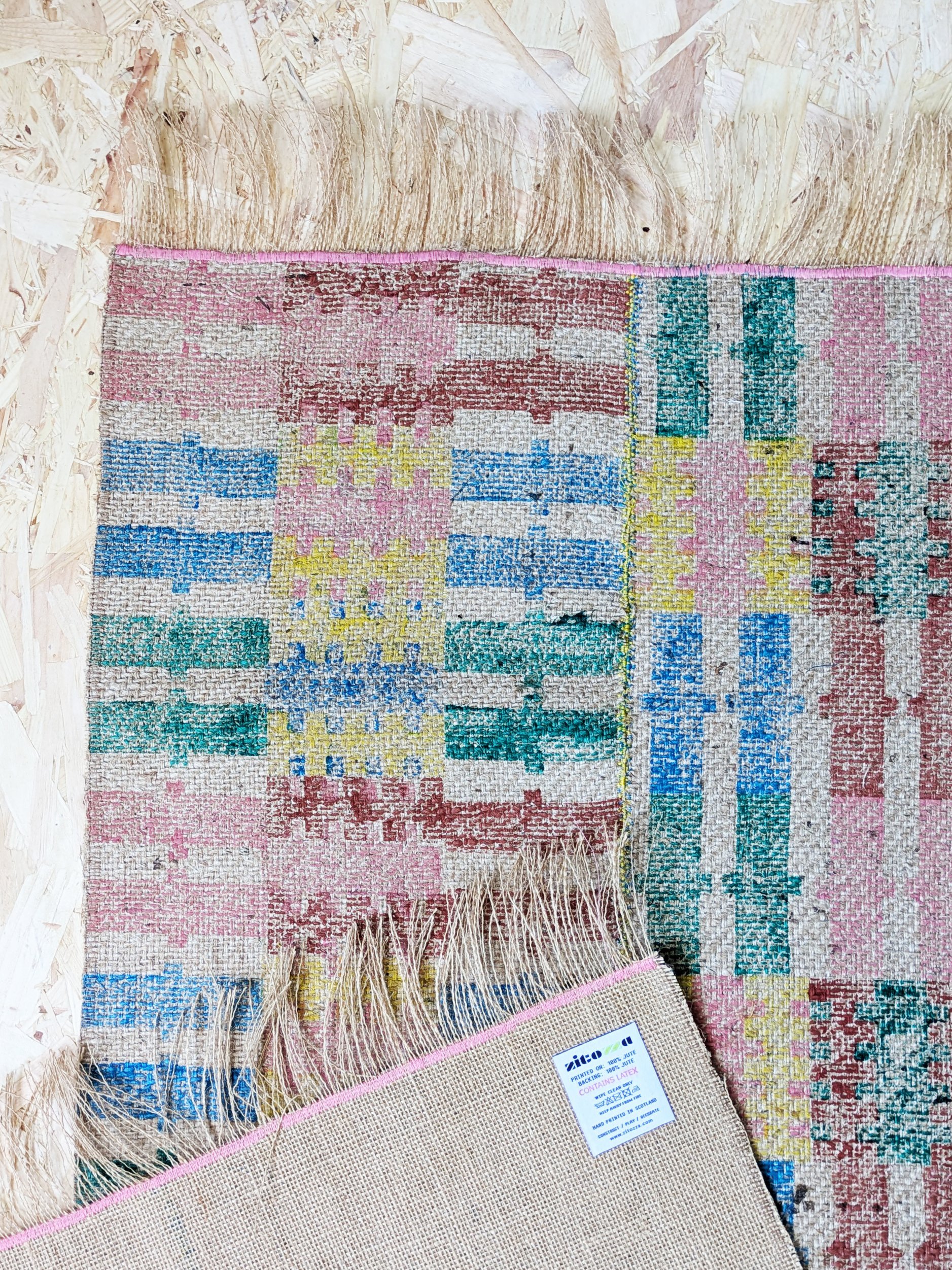 rug on floor with horizontal and vertical stripes stitched together in bold summery colours