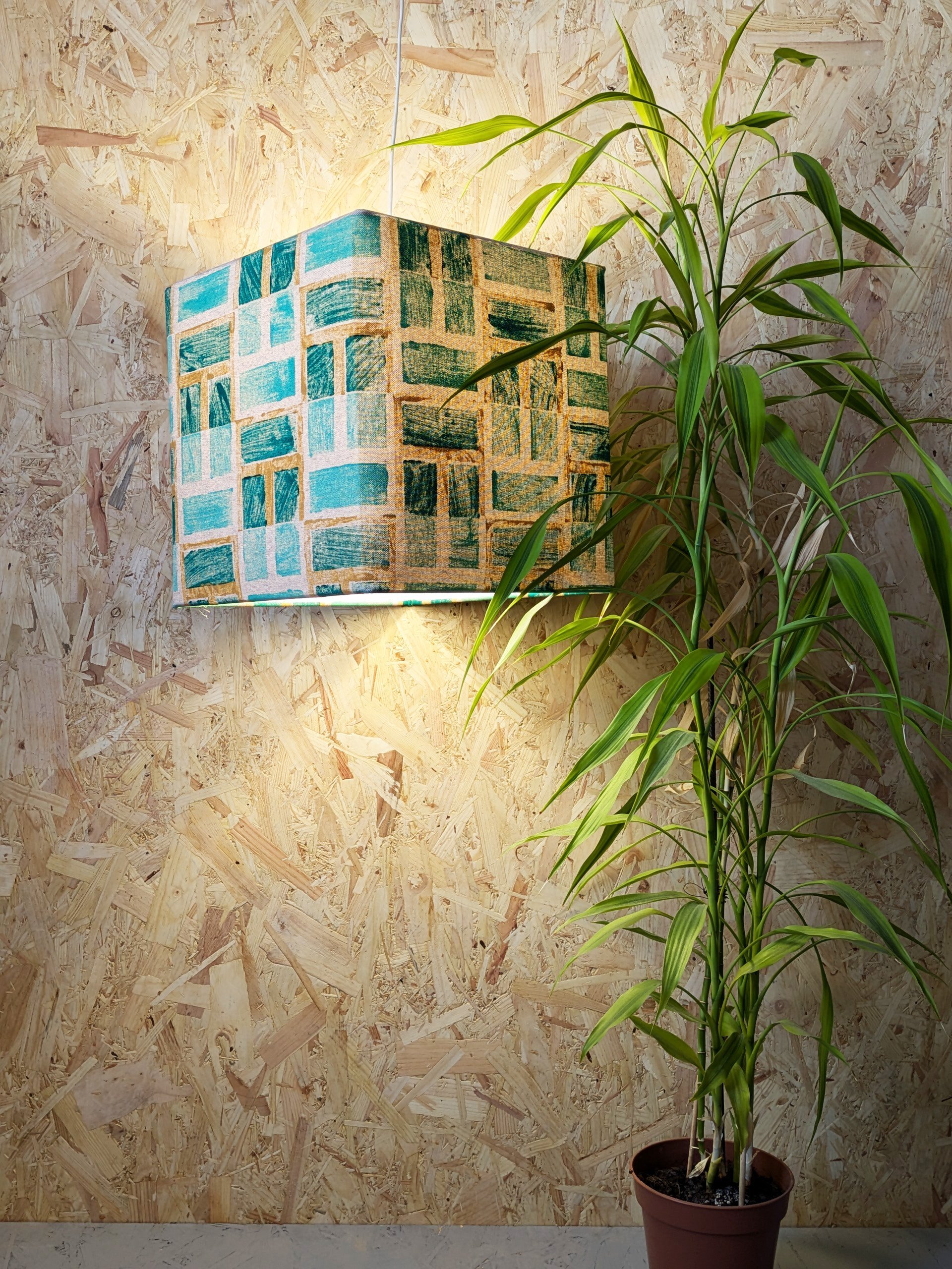 ambient light in tropical interior setting with lush green abstract printed geometric lampshade
