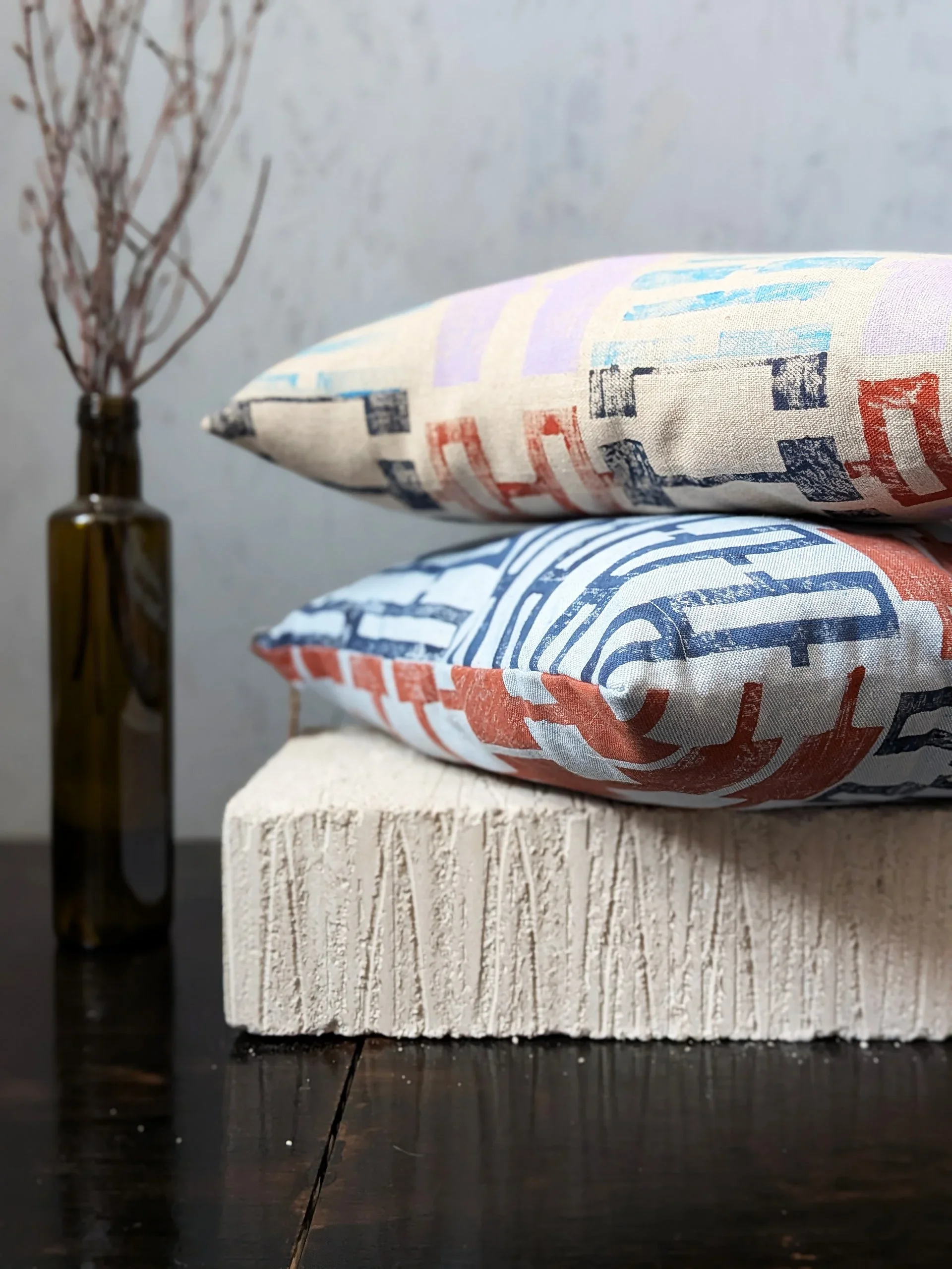 modern hand block printed cushions in pastel and blue stacked on each-other