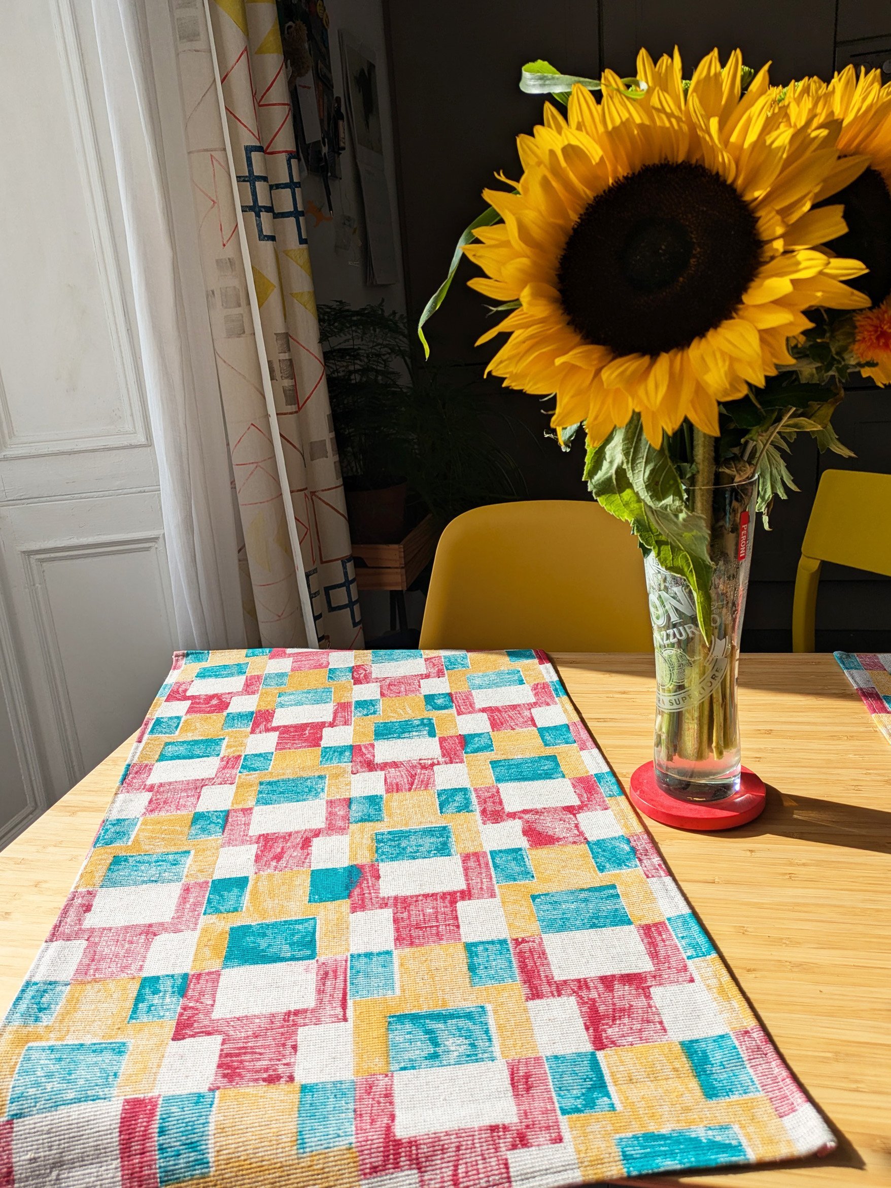 kitchen towel on table with bold, colourful pattern in hand block printed pixel-inspired design