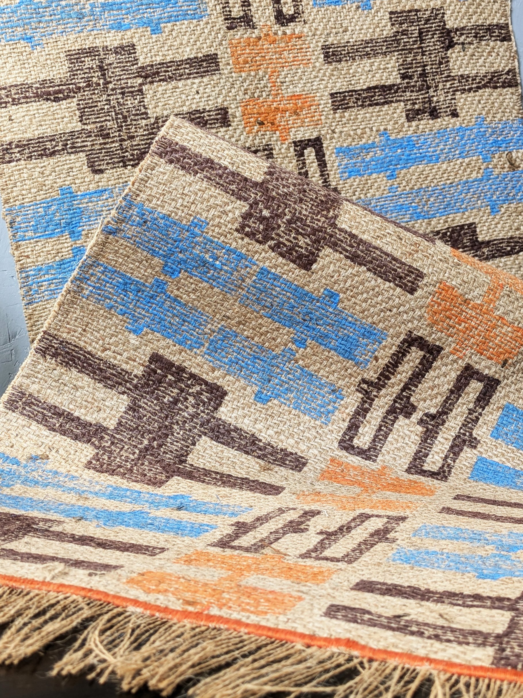 cosy interior scene with textured jute rug in warm colours and geometric, block printed aztec-inspired pattern
