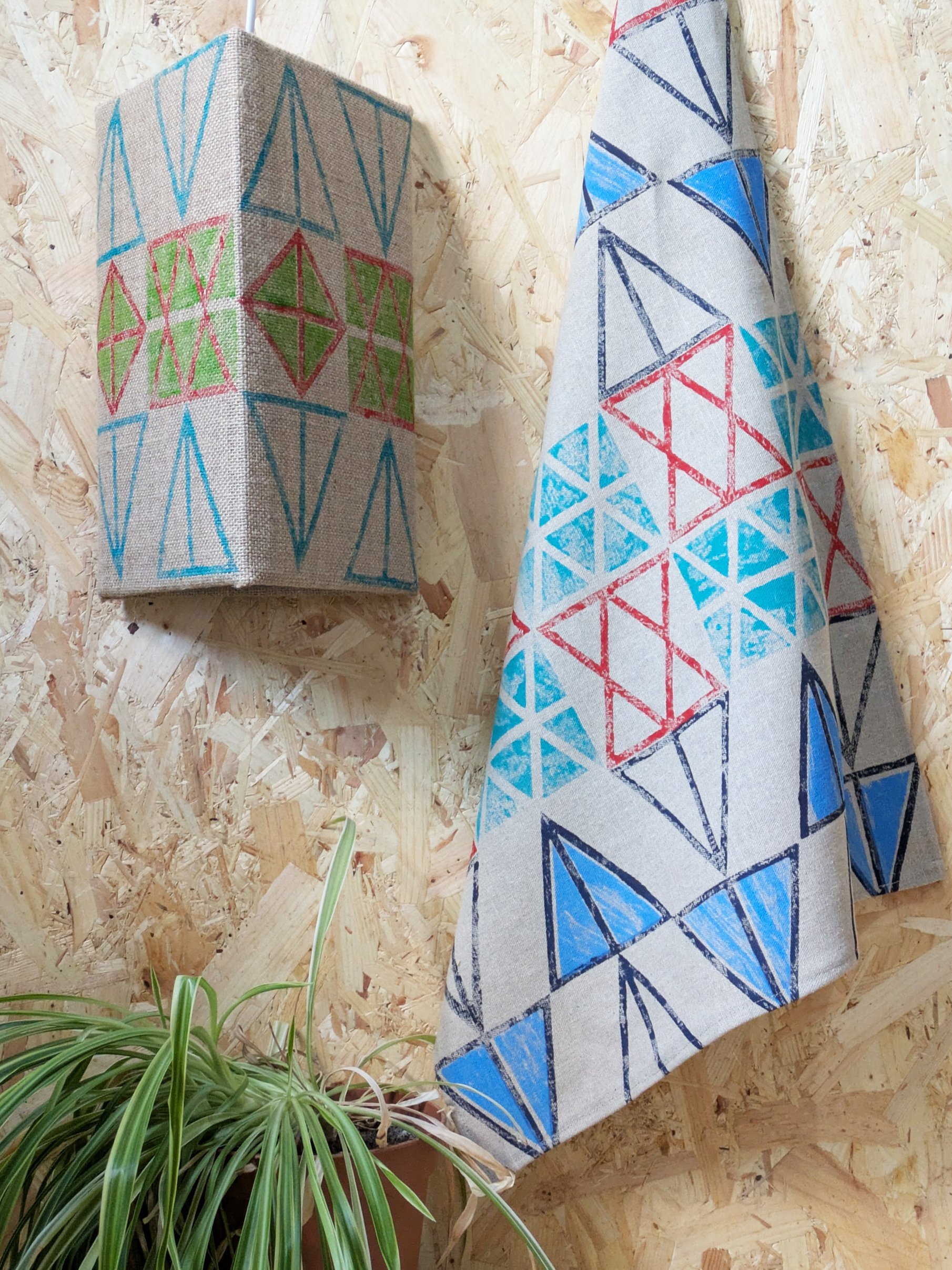 teatowel hanging on wall with triangular lampshade in teal, red and blue pattern