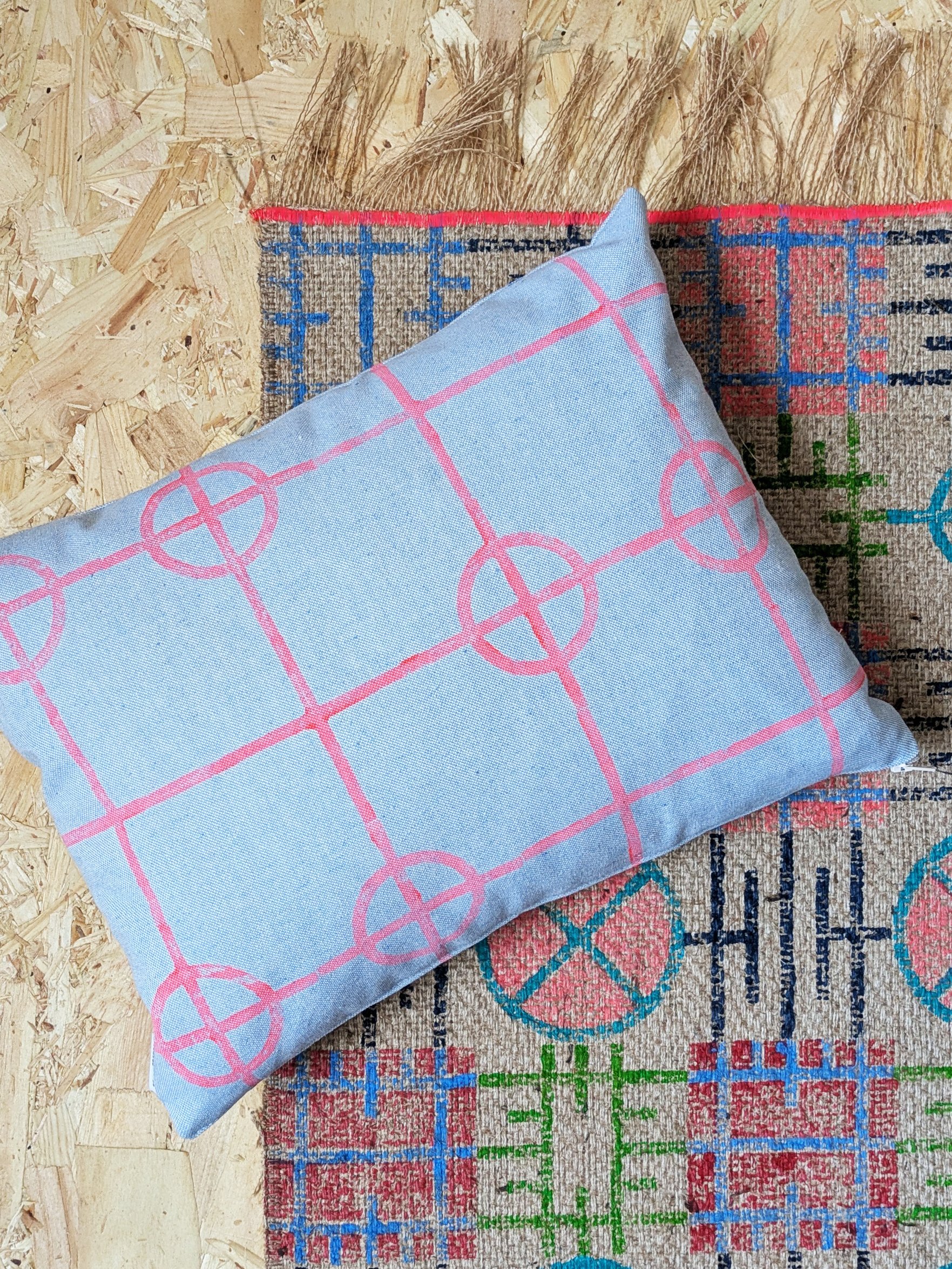 clean structured geometric patterns in neon colours on small cushion and jute rug