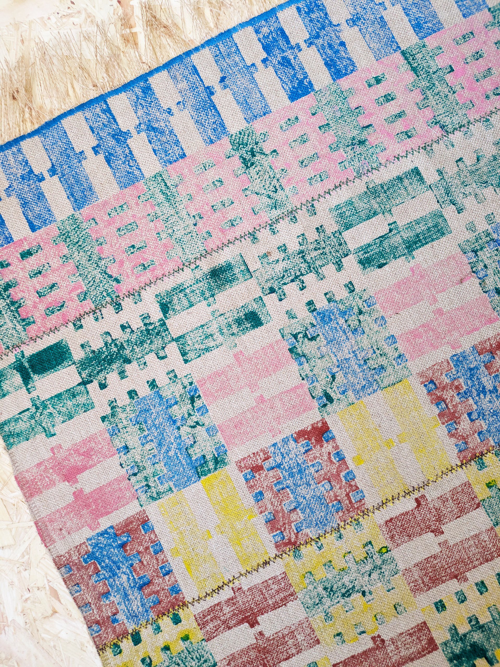 close-up detail of hand block printed pattern on colourful jute rug in dopamine decor stripes and checks