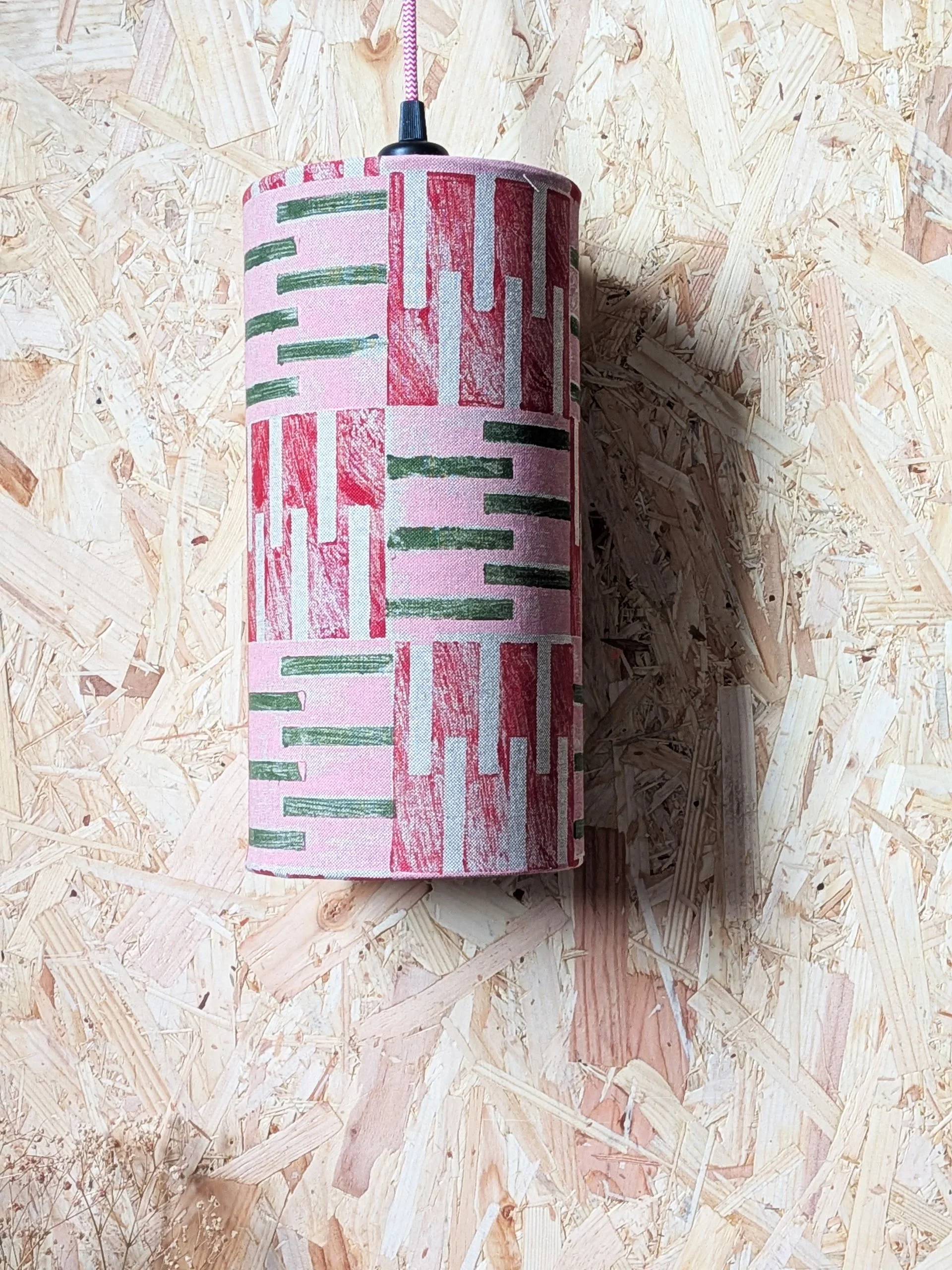 brutalism inspired block printed pattern on long cylindrical lampshade in pink and cherry red