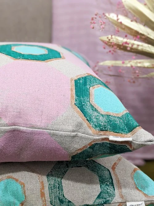 close-up detail of hand printed cushion with lush green and pastel colours in geometric pattern