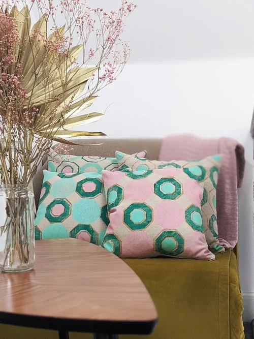 interior scene with geometric tile prints on cushions in pastel pink
