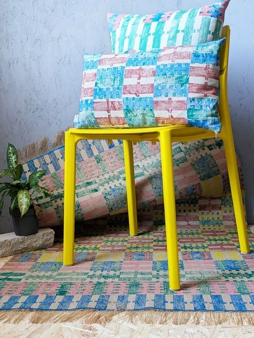 studio scene with plastic chair and hand printed rug in colourful stripe and check prints
