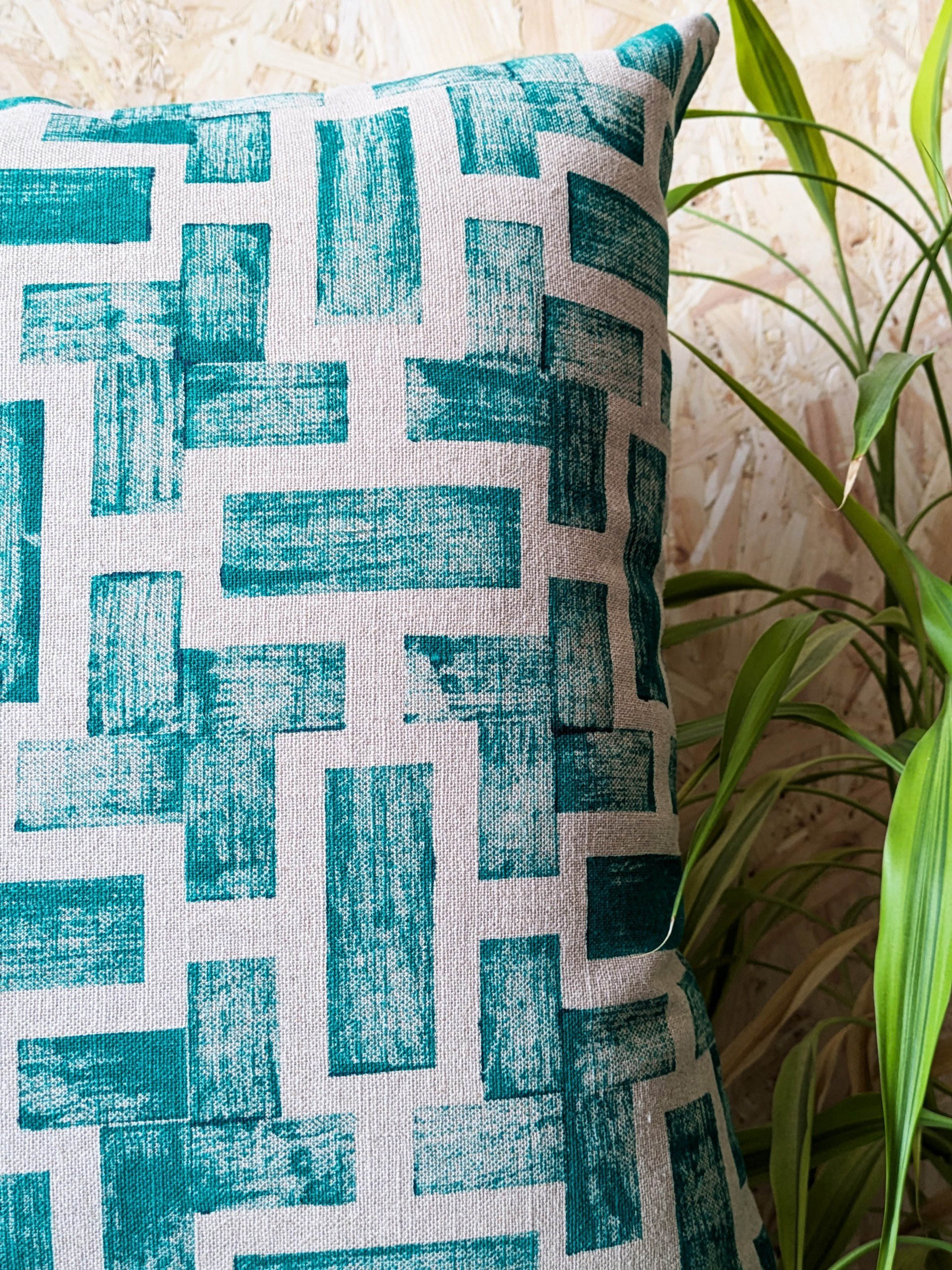 close-up detail of dark green abstract geometric print on luxury linen cushion