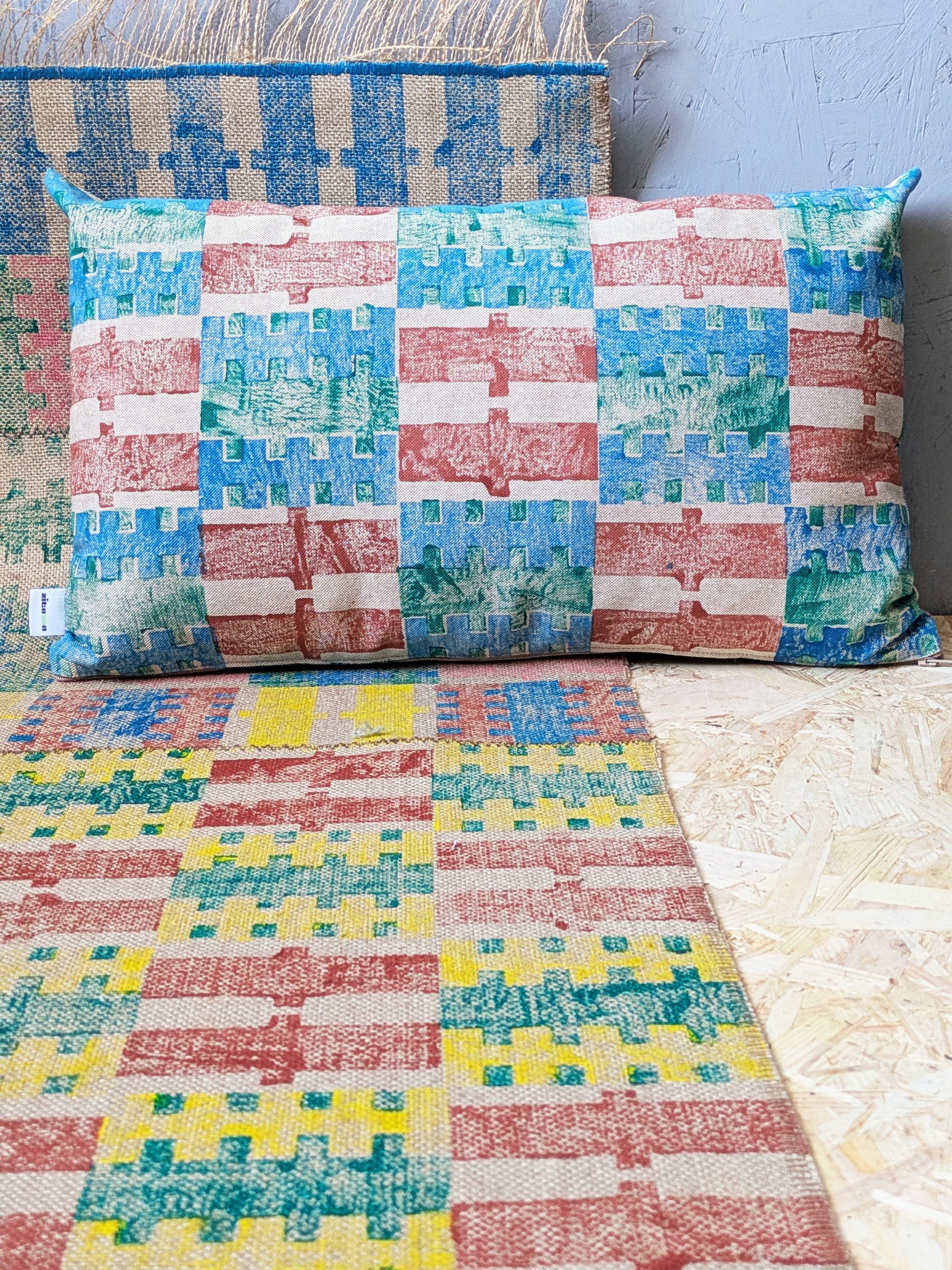 rectangular cushion on colourful rug with hand block printed check and stripe patterns