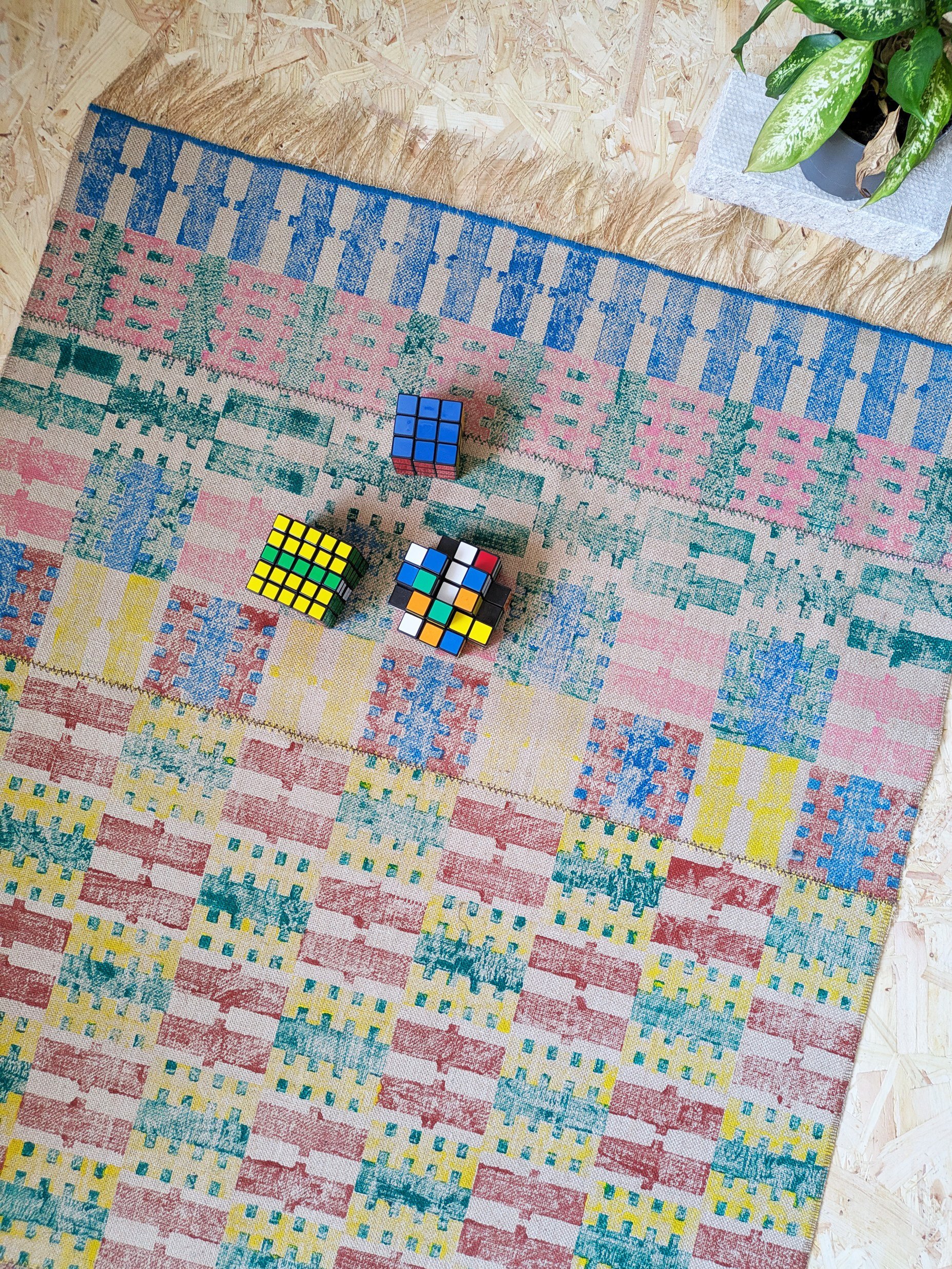 studio scene with striped and checked rug on floor with toys