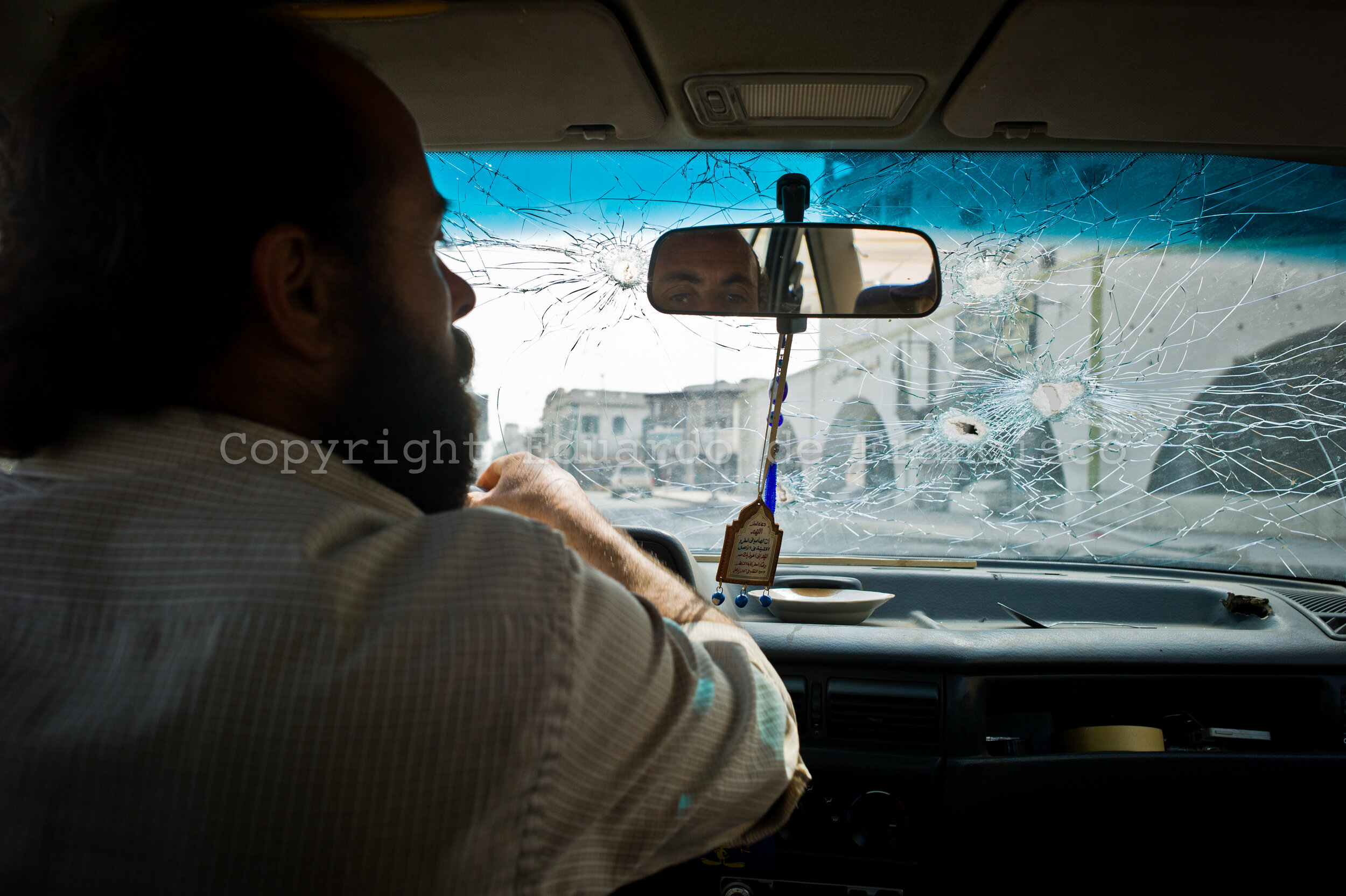  A man drives his car (extensively shot, with his family inside, one month before) around the center of Misrata 