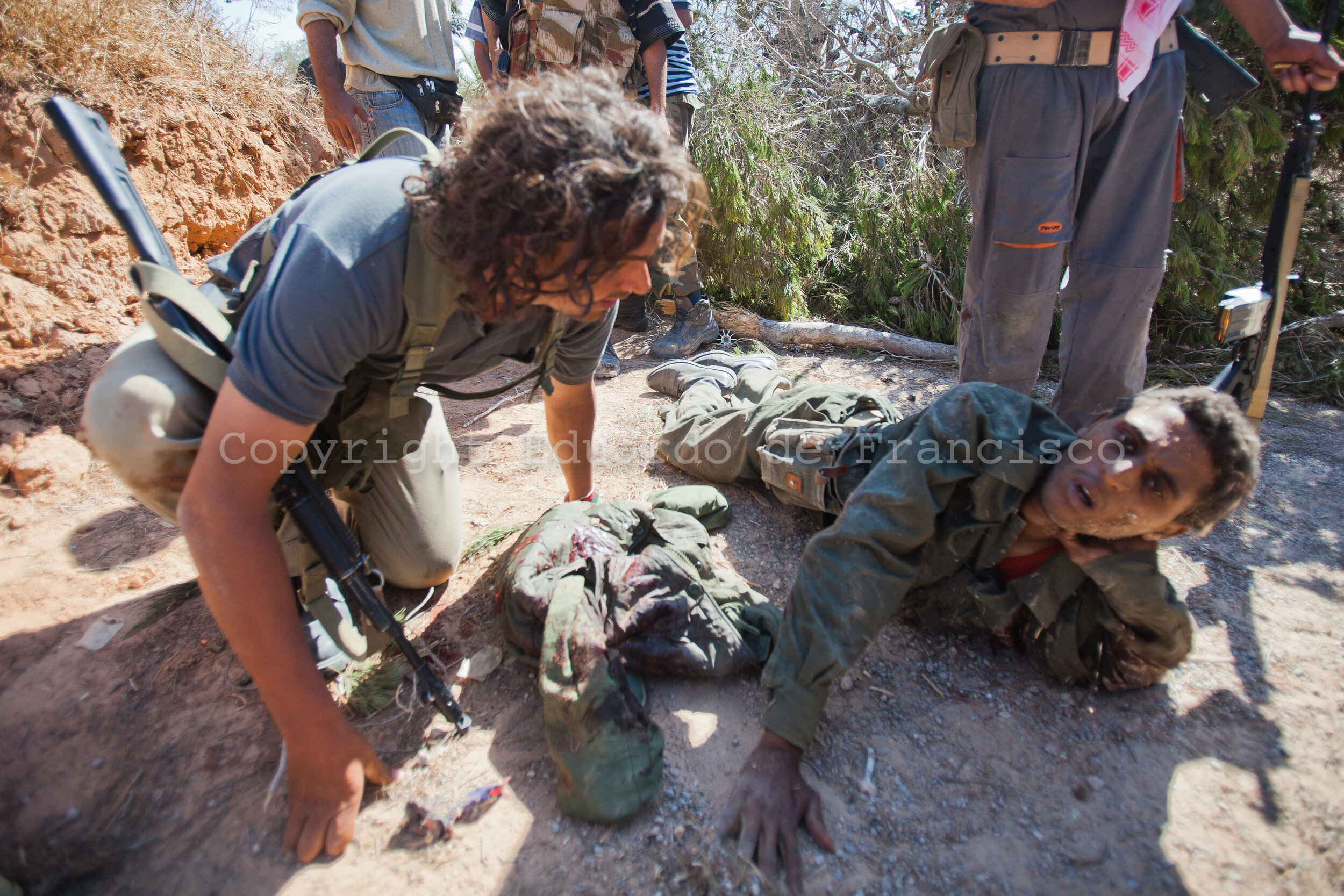  A group of rebel soldiers capture an injured loyalist soldier after taking over a position defended by Gadaffi's loyalists 