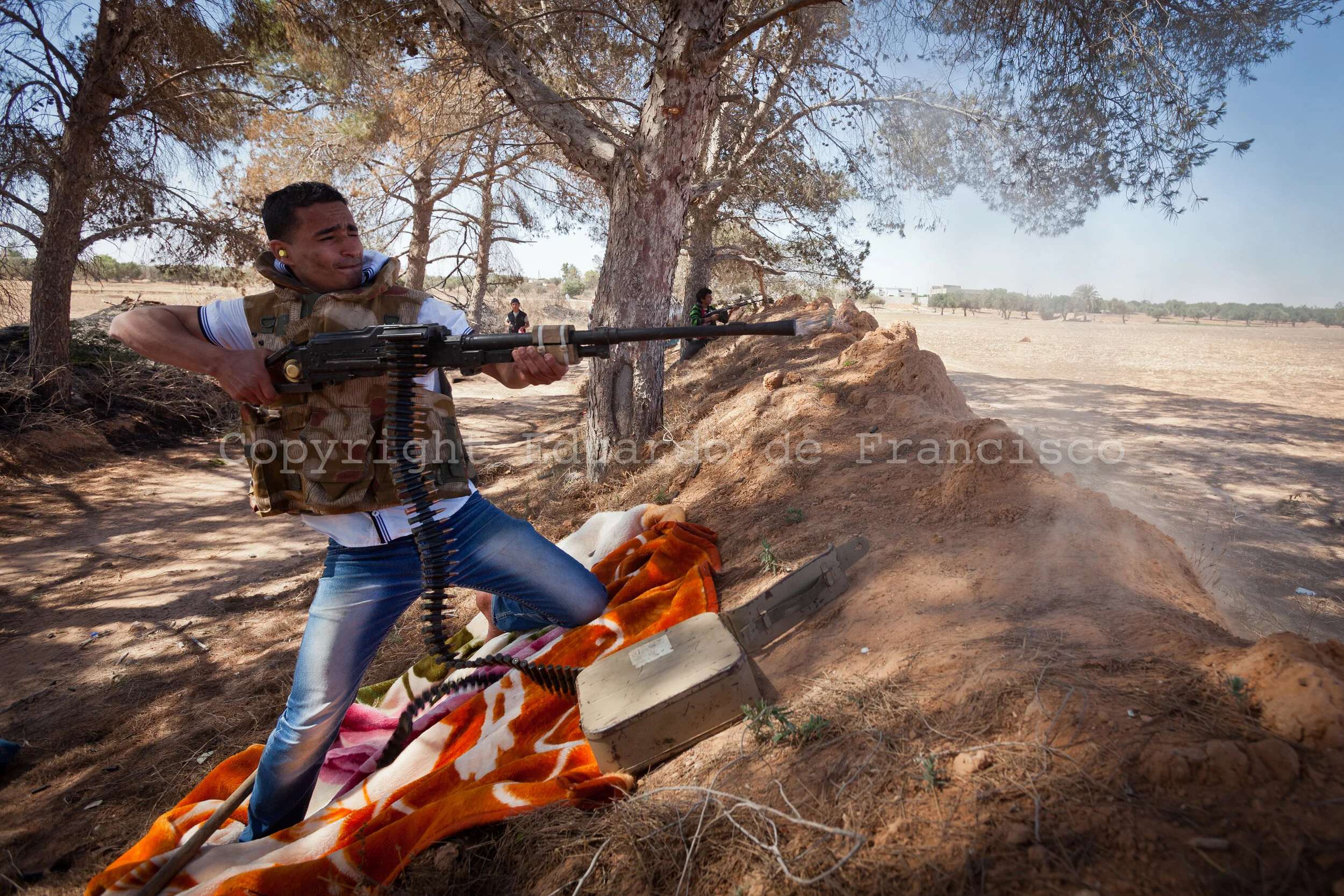 From an advanced position at the Ad Dafiniyah frontline, a rebel soldier fires over Gadaffi's positions
