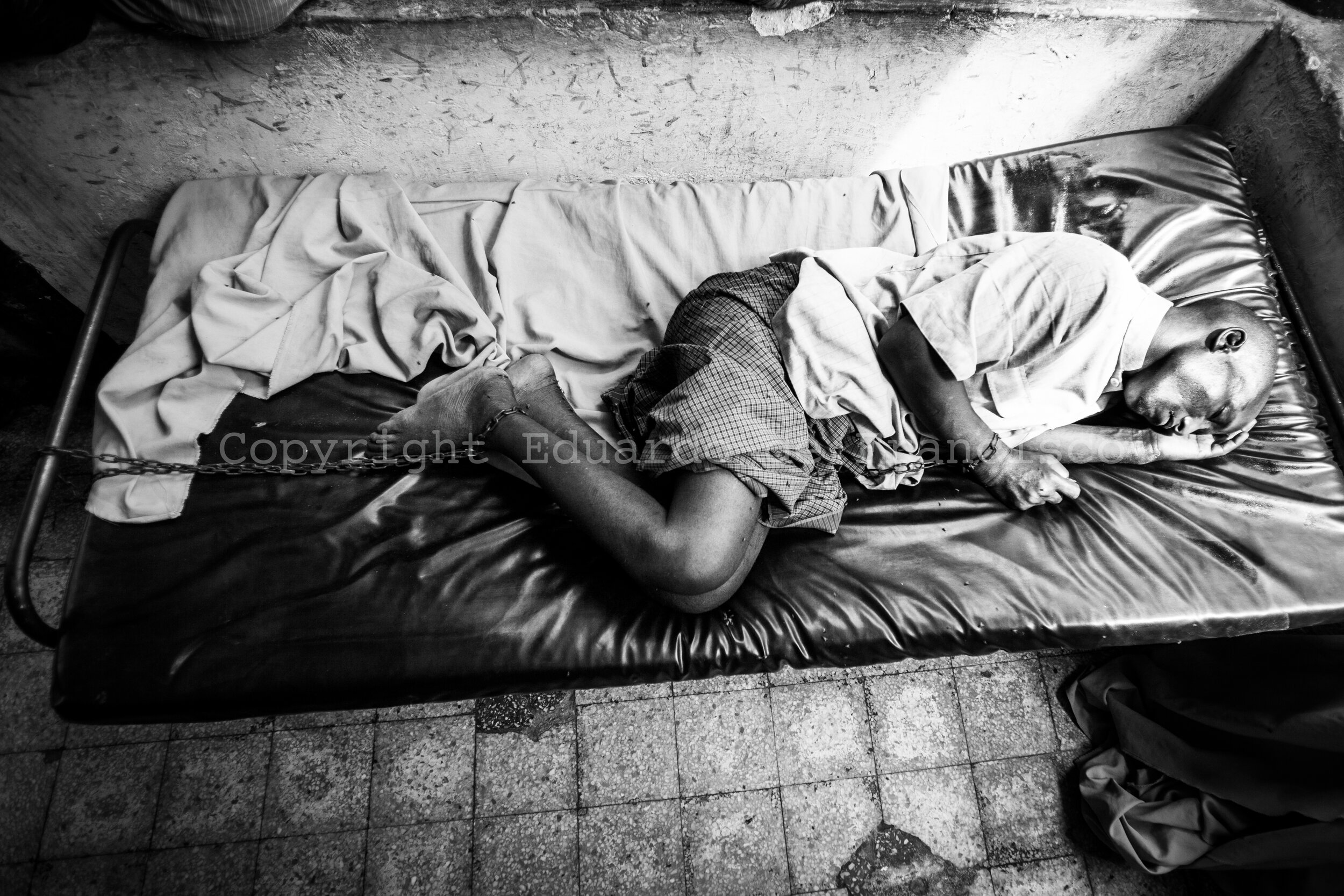  A chained patient sleeps at Habib Mental Health Hospital in Mogadishu. Although one in three Somalis suffers severe mental health disorders, assistance in psychological facilities is practically non-existent. The population believes that mental heal