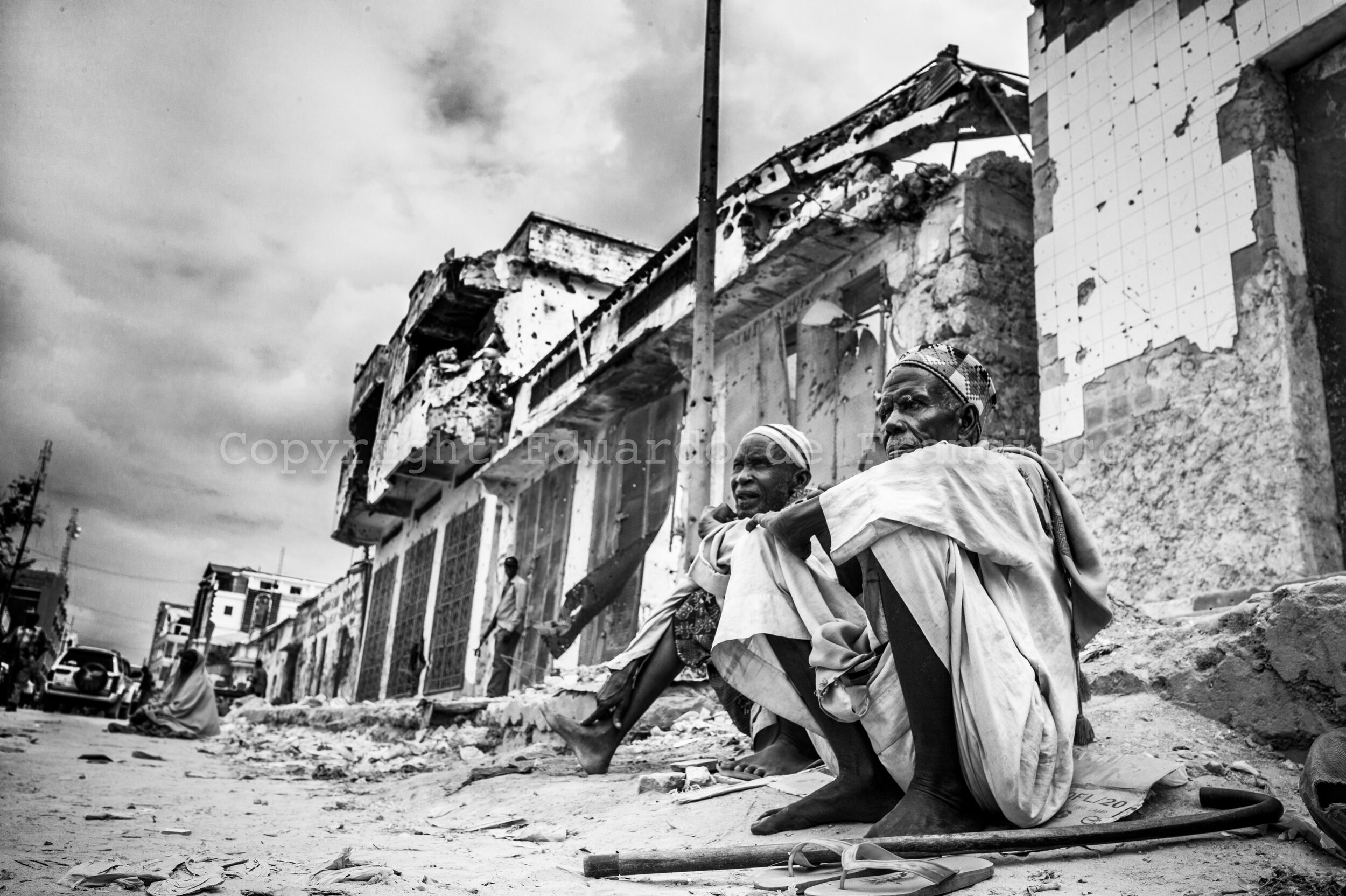  Two old men in the street going to Bakaara Market in Mogadishu, the biggest commercial centre of Somalia and still fiercely disputed by diverse militias from the city that finance themselves by taxing the shop owners 