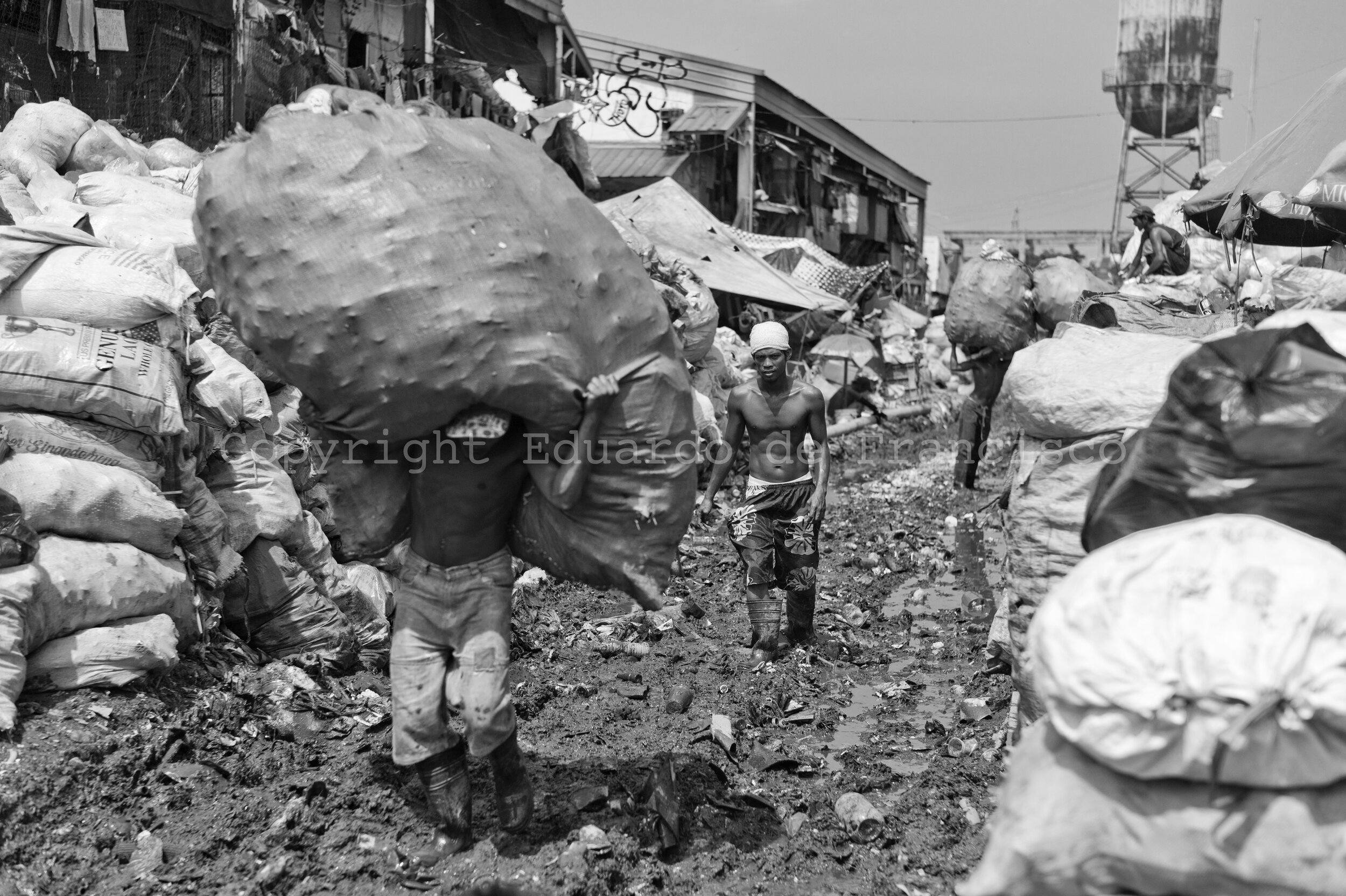  Daily workers carry bags containing rubbish already classified and ready for treatment. 