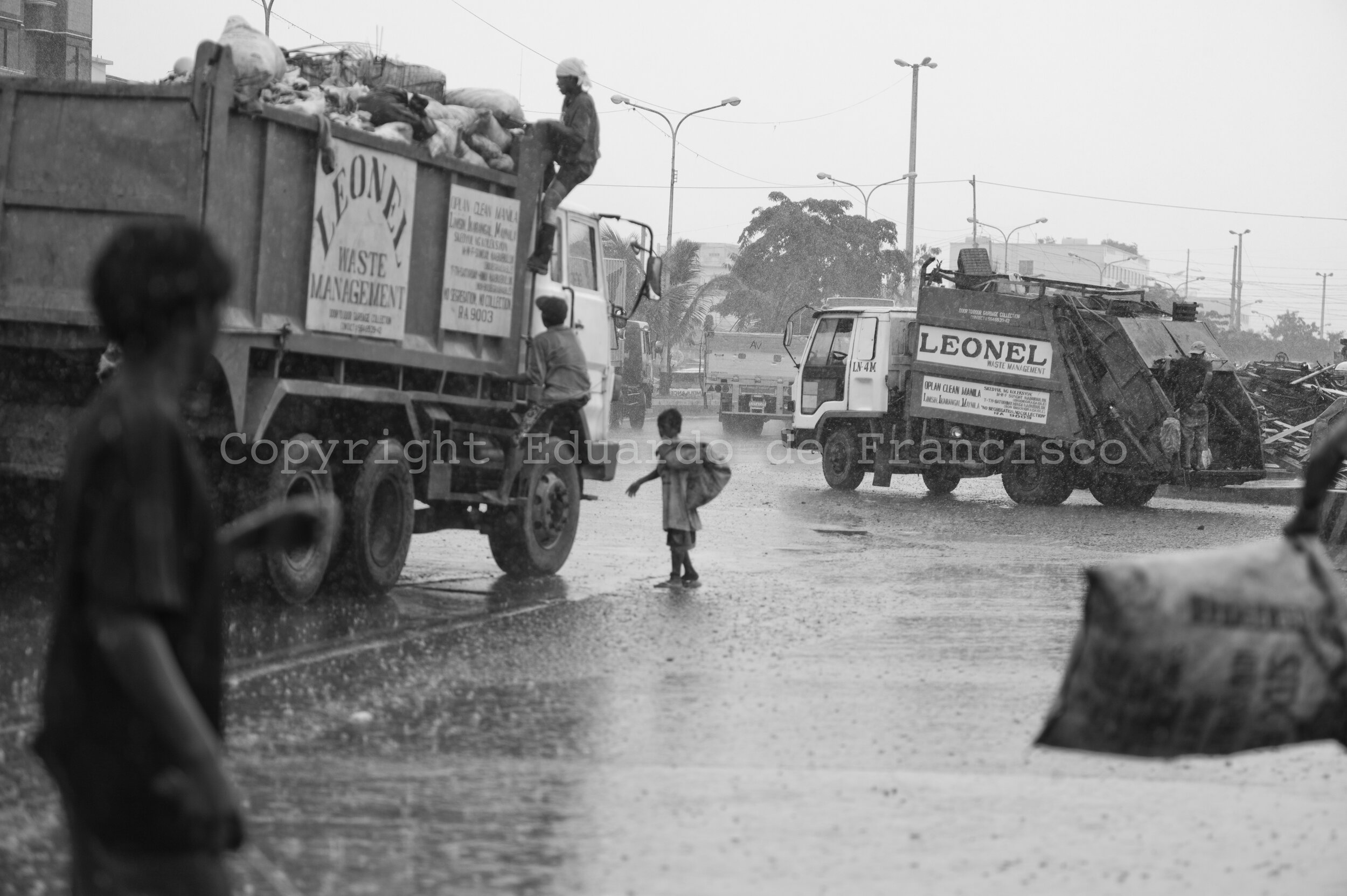  Before the trucks from the concesionary company, loaded with rubbish, get into the terminal where the rubbish is taken out of Manila in big barges, groups of children climb into them to fish the most valuable picks, in particular aluminium cans: one