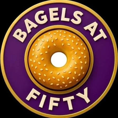 Bagels at Fifty logo: a sesame bagel in a purple and gold roundel