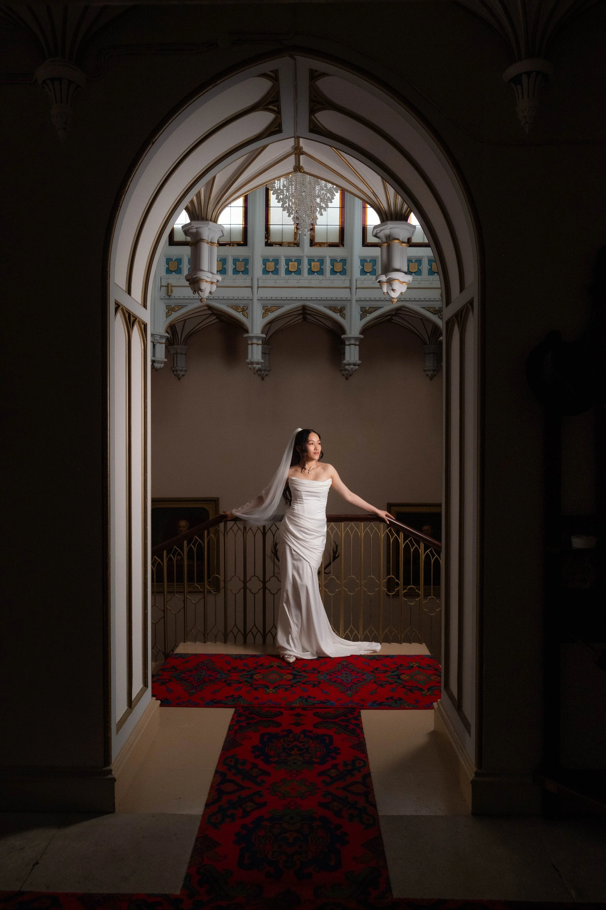 Bride framed with beautiful arched doorway standing on red carpet