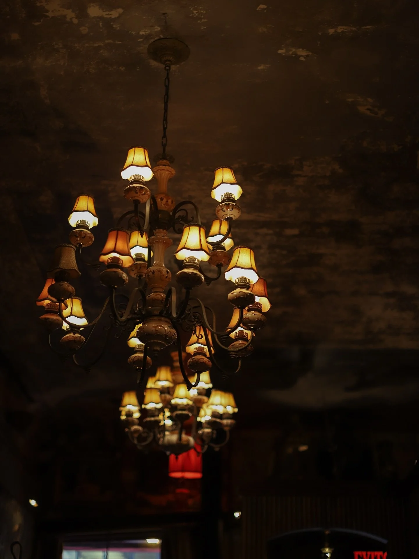 NYC restaurant El Quijote showing historic ceiling, booth seating, four tops, and vintage french chandelier pendant lights. Hospitality interior design and consultancy by Studio Sio, New Zealand
