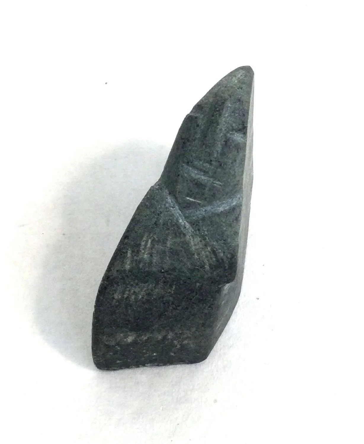 Lucy Tasseor Tutsweetok ᓗᓯ ᑕᓯᐅ ᑎᓯᑕ (1934-2012) Arviat/Eskimo Point ᐊᕐᕕᐊᑦ, Faces (#25.11.58), c.1972, basalt, 1.25 x 1.5 x .25 inches (3 x 3 x 1.5 cm), $295 Cdn.