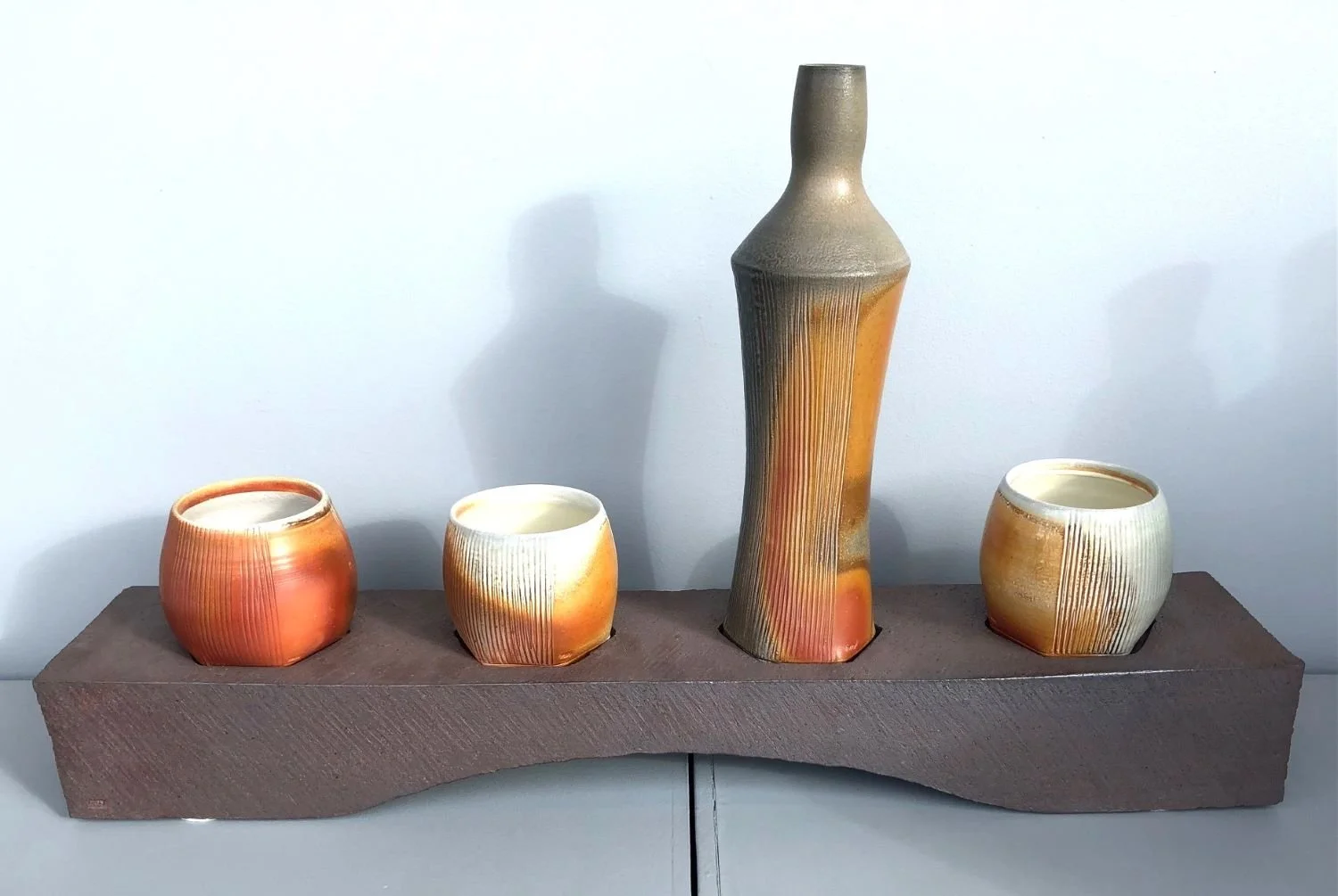 Ceramic Set, soda fired porcelain cups and bottle with stoneware base, 15 x 26 x 4.75 inches (38 x 66 x 12 cm), $700.00 Cdn.