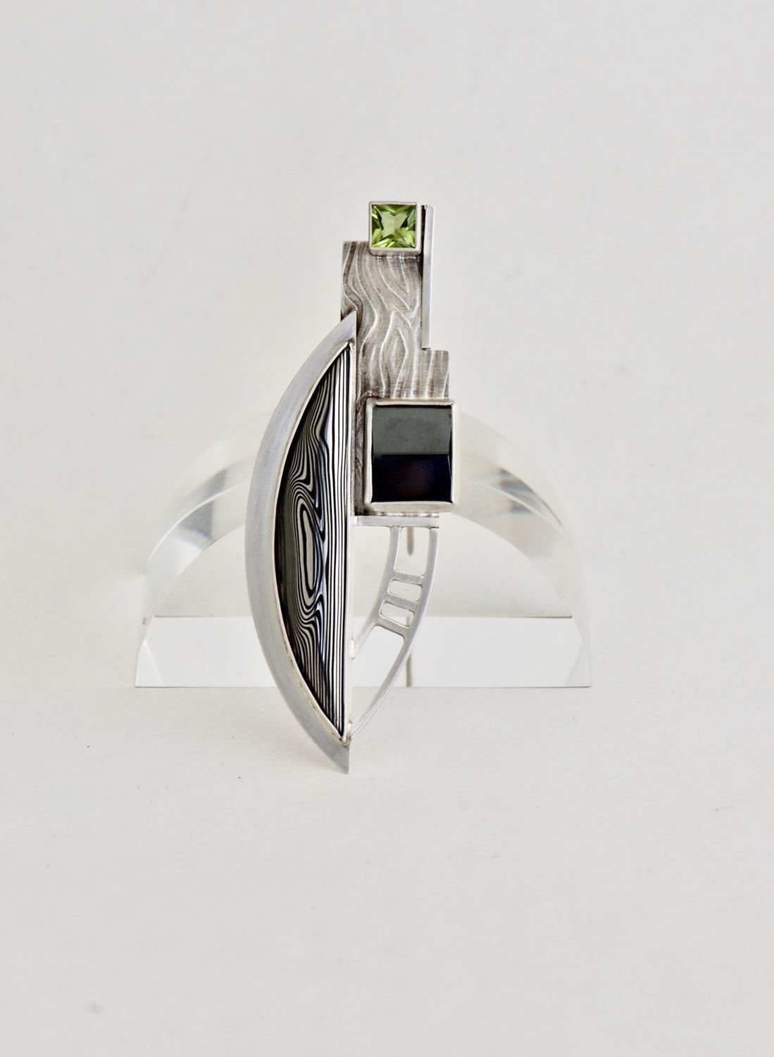 Marden Brooch, 2019 (Frank Lloyd Wright Series, JDA53),  sterling, damascus, hematite, peridot, 1.4 x 3 inches (3 x 7.6 cm), - the inspiration: floor plan for the FLW Luis Marden House (1953, The Falls Estate, Virginia, USA), $1000.00 Cdn.