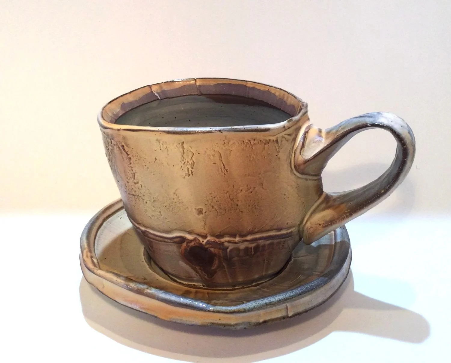 Confluence Mug With Saucer (#26.2.54), 2026, low soda-fired earthenware, 4.5 x 5.5 x 6 inches (11 x 14 x 15 cm), $125 Cdn.