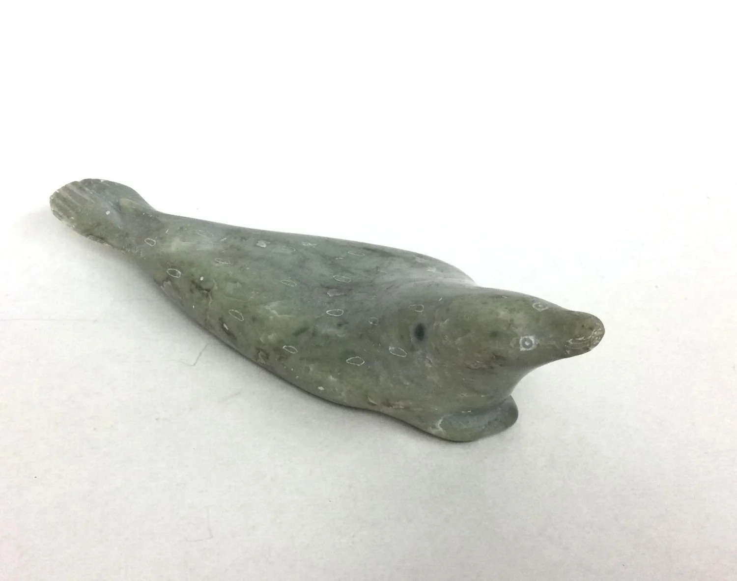 Markusi Kalingo E9-991 (1899-c1986) (Salluit/Suglak, ᓴᓪᓗᐃᑦ, Nunavik), Seal, c.1960, light green serpentine, 2.5 x 8.5 x 2.5 inches (6x21.5x6cm), $550 Cdn.