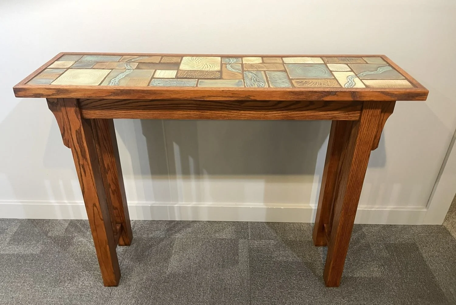 Prairie Rivers Hall Table (#26.5.20), 2026, handbuilt dark red oak, carved and glazed tile top, 31.25 x 11.5 x 41 inches (79 x 29 x 104 cm), $2400 Cdn.
