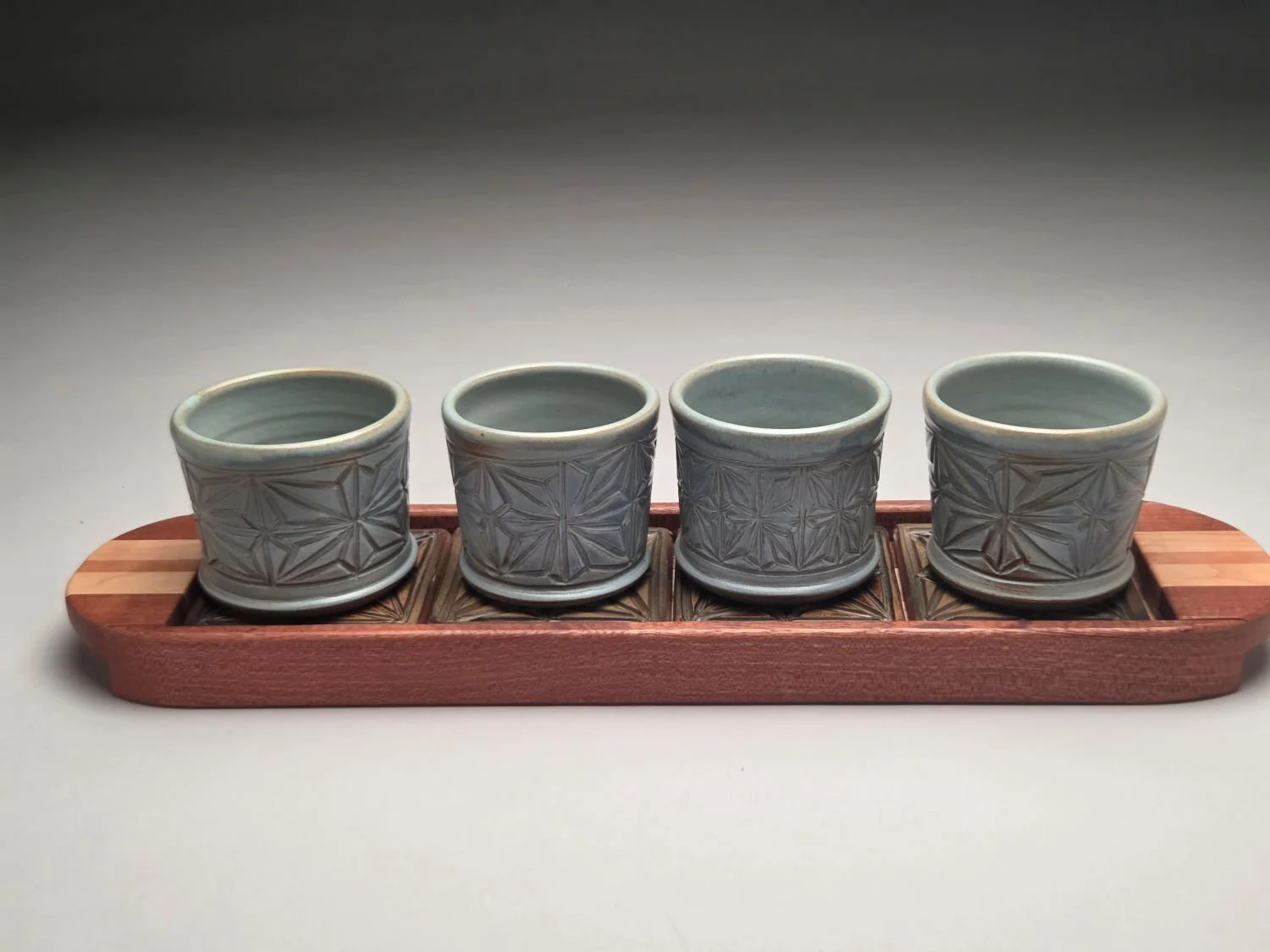Kumiko Blue Skies Whiskey Cups, Coasters & Tray Set (#26.5.15), 2026, hand carved, glazed stoneware, handcrafted wood (4 cup, tray, coasters), 4.5 x 5 x 19.5 inches (11 x 12.5 x 29.5 cm), $265 Cdn.