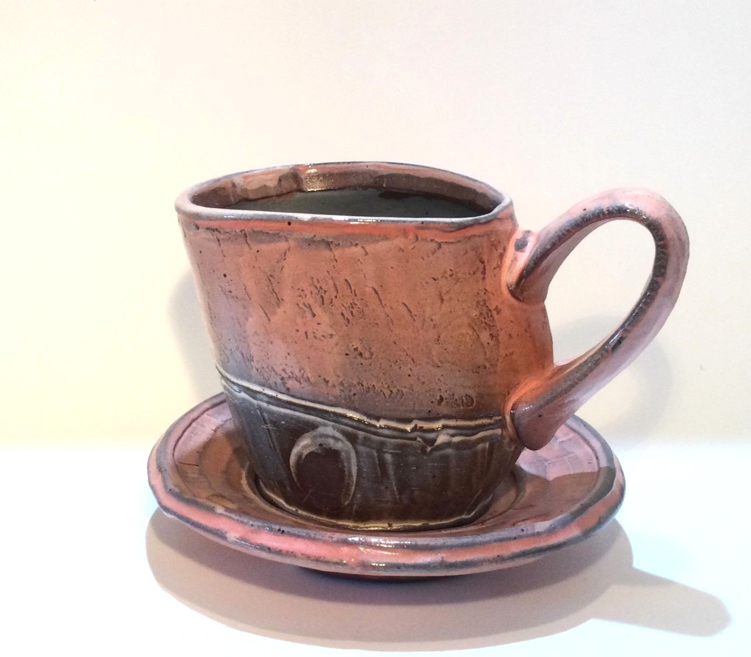 Confluence Mug With Saucer (#26.2.53), 2026, low soda-fired earthenware, 4.5 x 5.5 x 6 inches (11 x 14 x 15 cm), $125 Cdn.