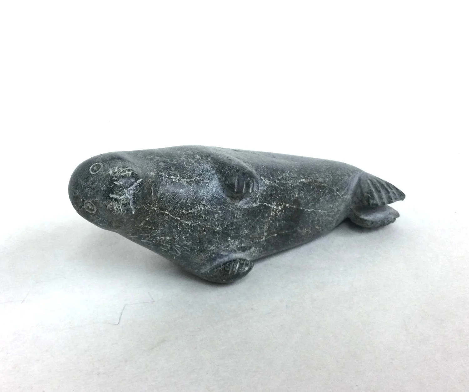 Eyeseak Padluq E7-1550 (1966-) Kimmirut / Lake Harbour ᑭᒻᒥᕈᑦ, Resting Seal, c.1980s, steatite/soapstone, 2.5 x 6 x 2.25 inches (6x15x6 cm), $450 Cdn.
