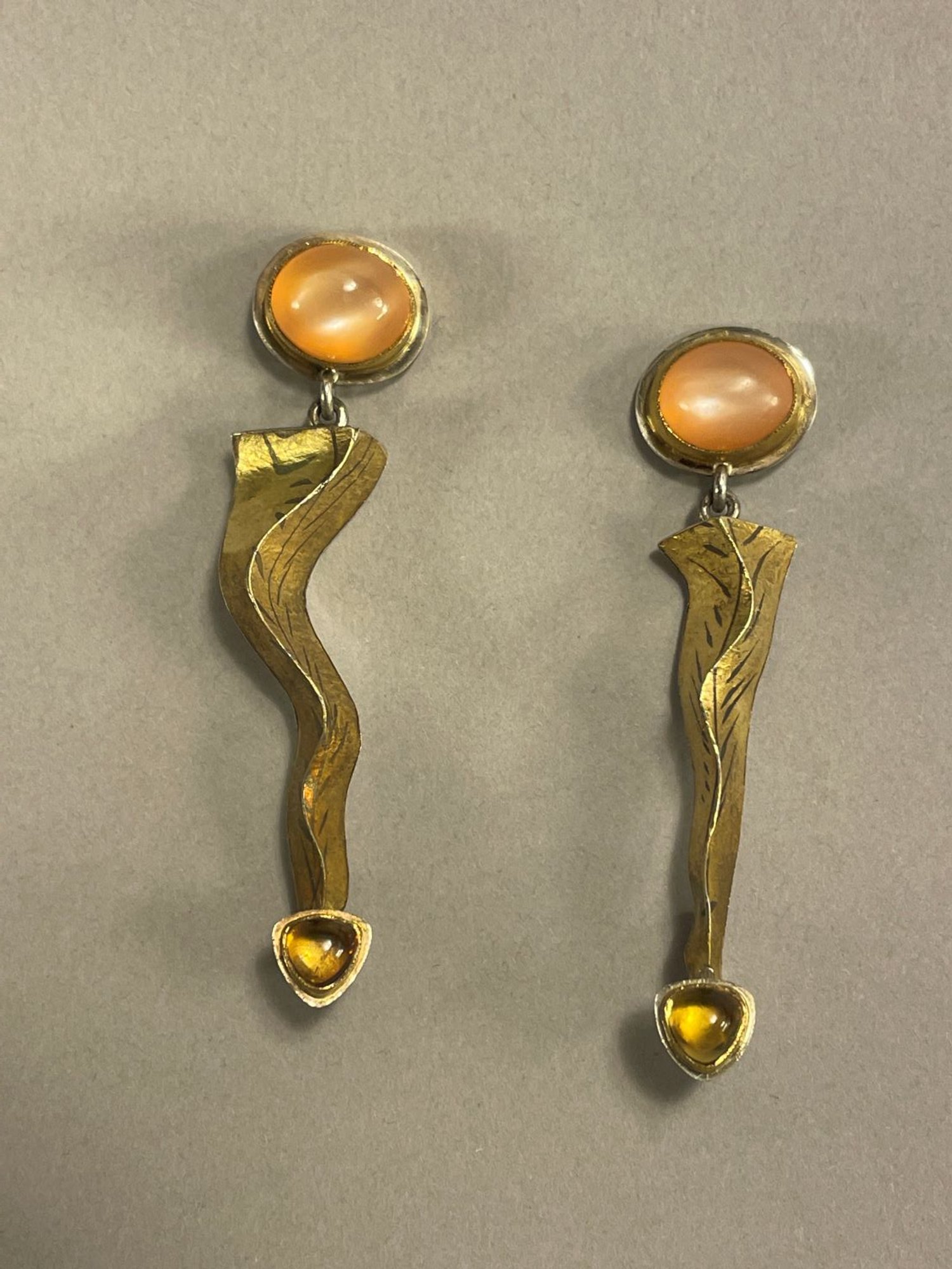 ‘Stalagtite’ Earrings (Swoop Series), 1993, materials 18k gold laminate, sterling, 24k Bezels, Oval Peach moonstones, Trillion
Citrines, each (1.4x1.2x6cm), $1100 Cdn