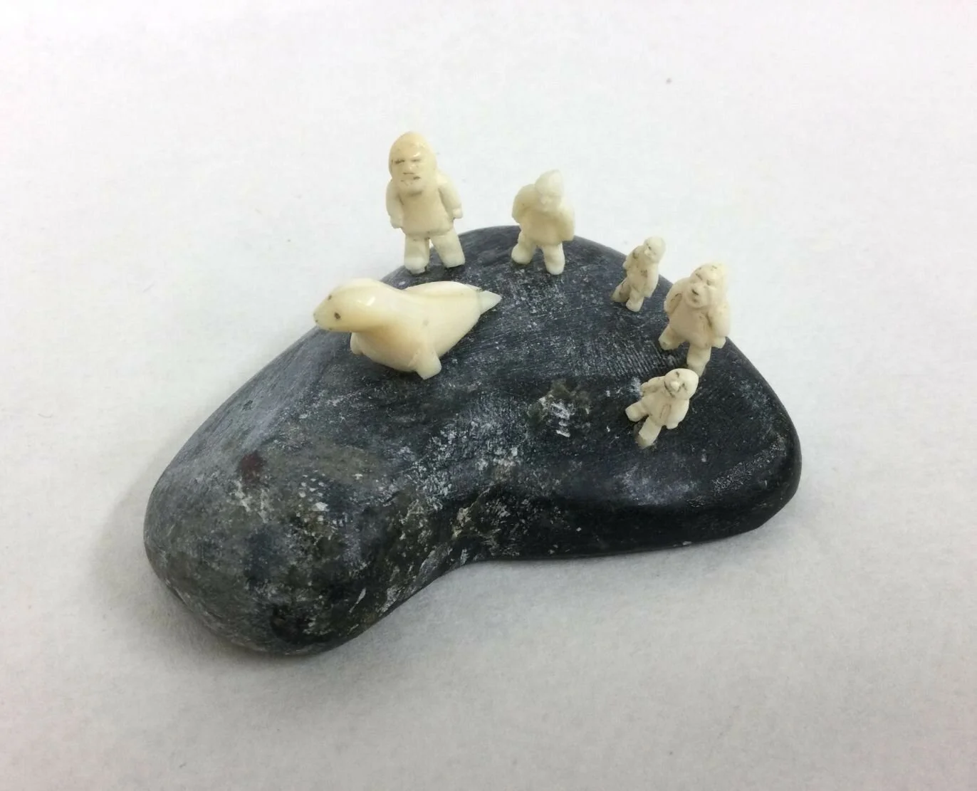 Mark Tungilik, ᒪᑭ ᑕᒐᓕ (1913-86), Naujaat / Repulse Bay ᓇᐅᔮᑦ, Mini Scene (Five Figures and Seal), n.d., stone and ivory, 1.25 x 2.25 x 2 inches (3.5x6x5 cm), signed in syllabics, $950 Cdn ---- note - export restrictions apply.